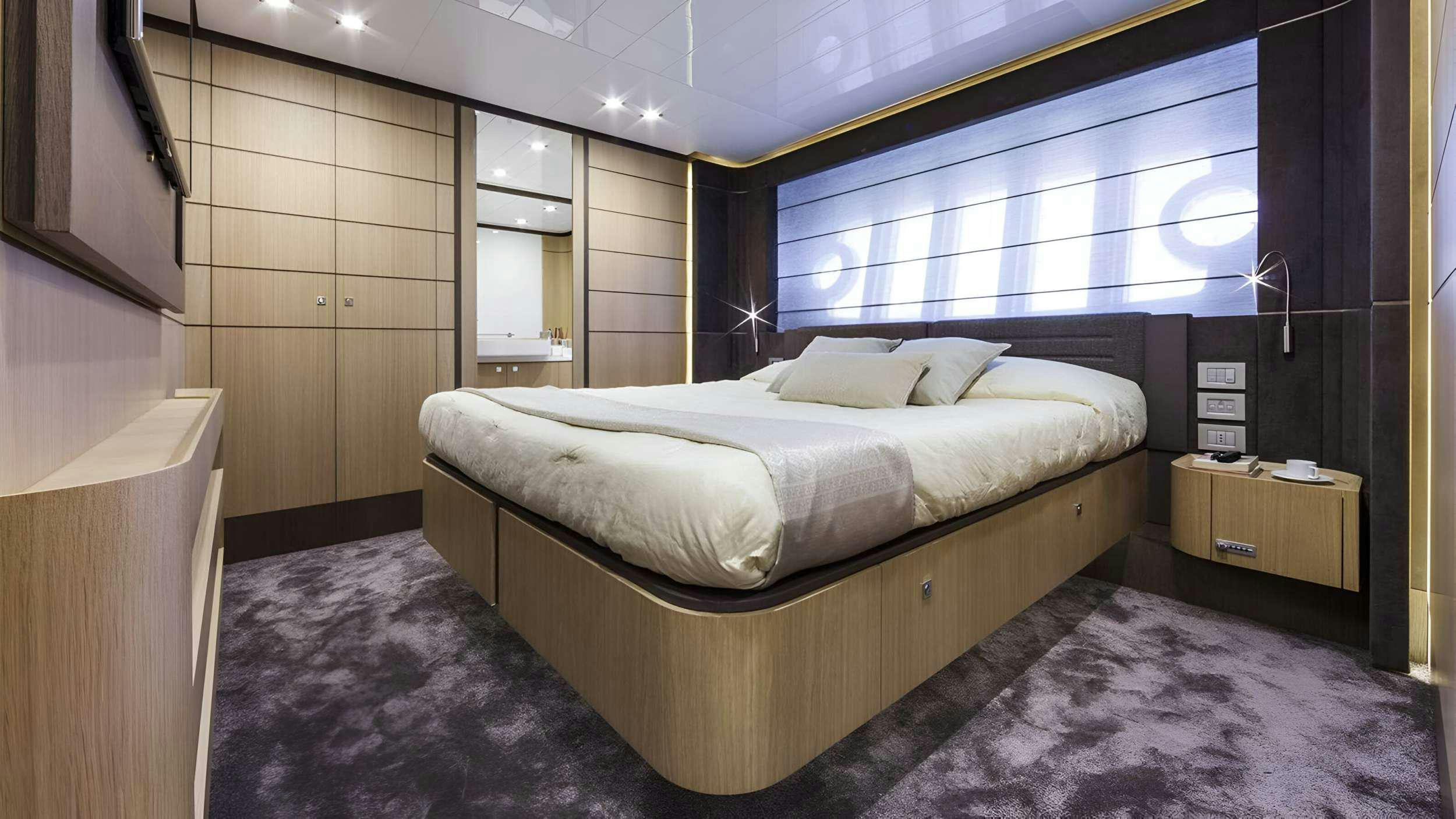 a room with a bed and a window aboard IVA Yacht for Charter