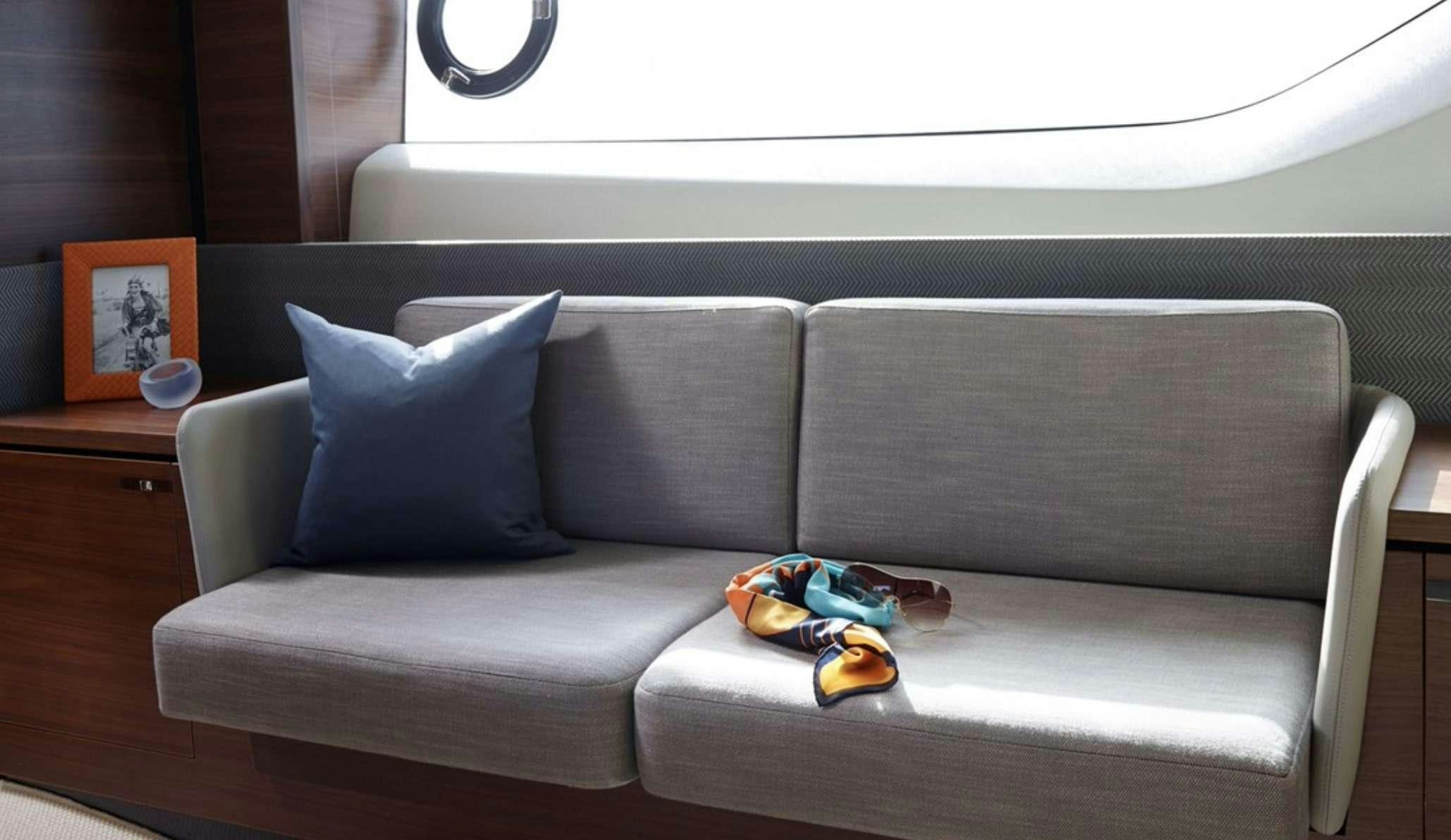 a couch with a blue pillow and a pair of shoes on it aboard FAR & AWAY Yacht for Charter