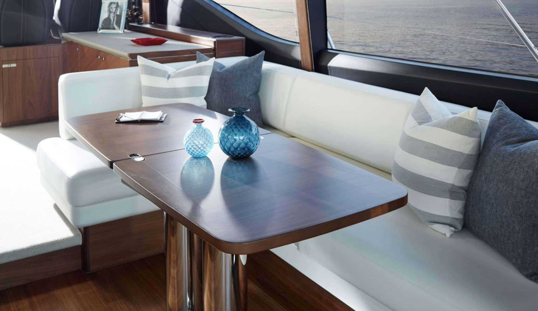 a white couch with pillows and a coffee table with a white coffee table aboard FAR & AWAY Yacht for Charter