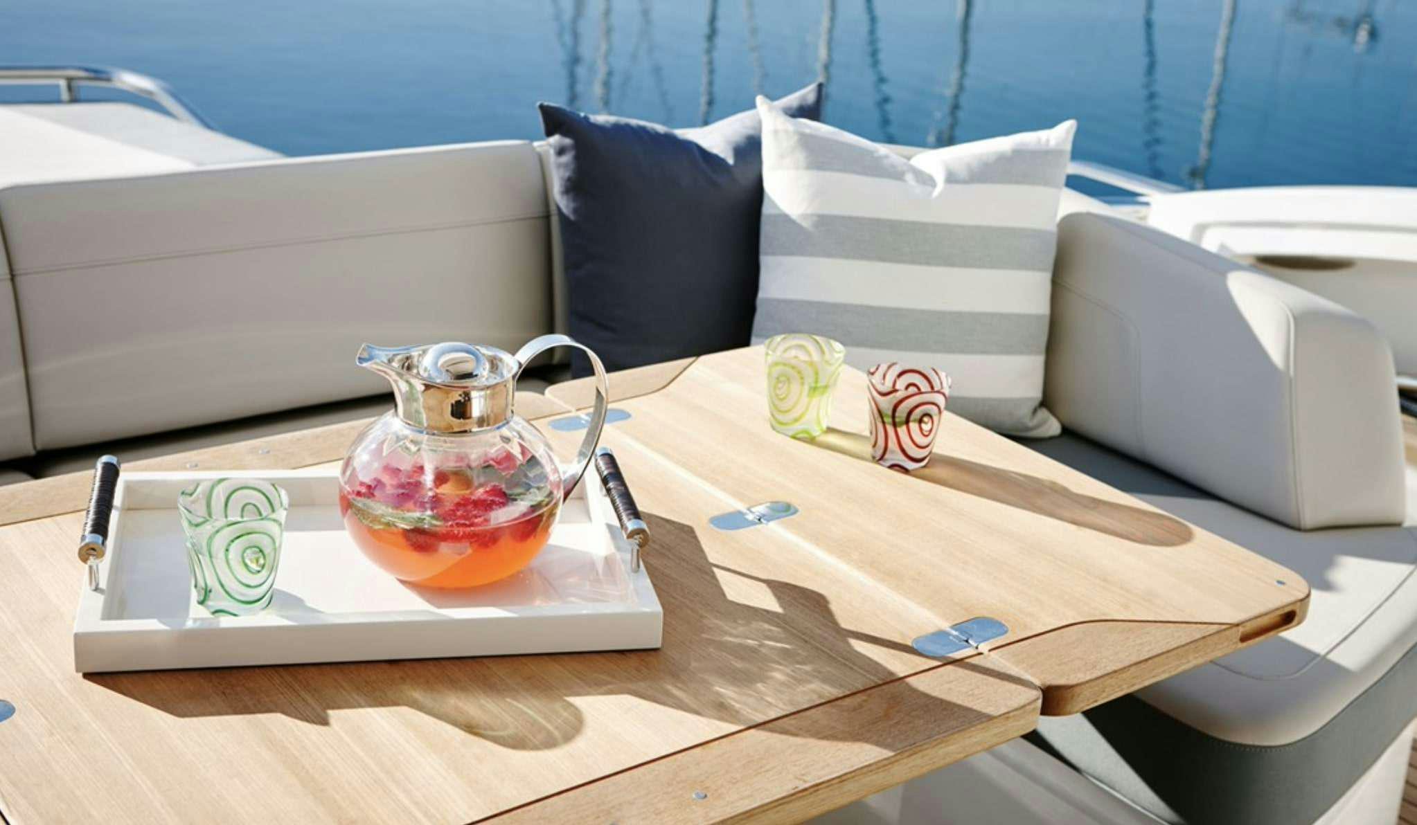 a glass jar with a lid on a table with a white couch and a white sofa in the aboard FAR & AWAY Yacht for Charter