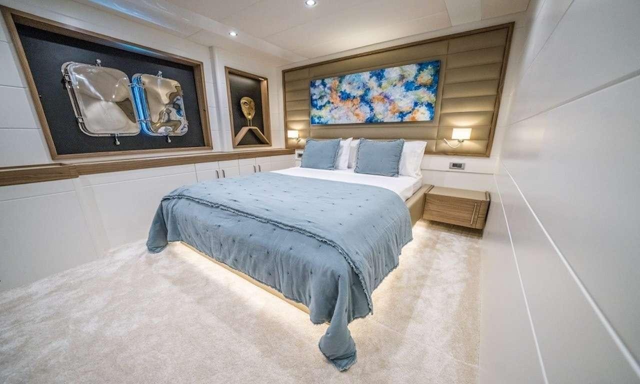 a bed with a blue blanket aboard DEEP WATER Yacht for Charter