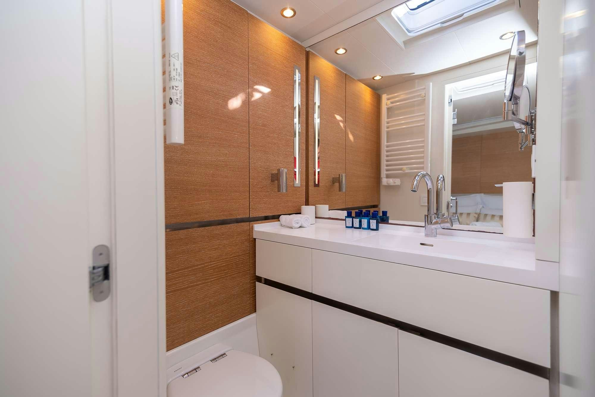 a bathroom with wooden cabinets aboard BUBBLES Yacht for Charter
