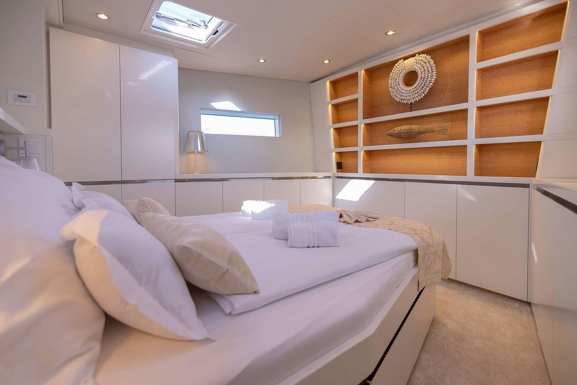 a room with a bed and a fan aboard BUBBLES Yacht for Charter