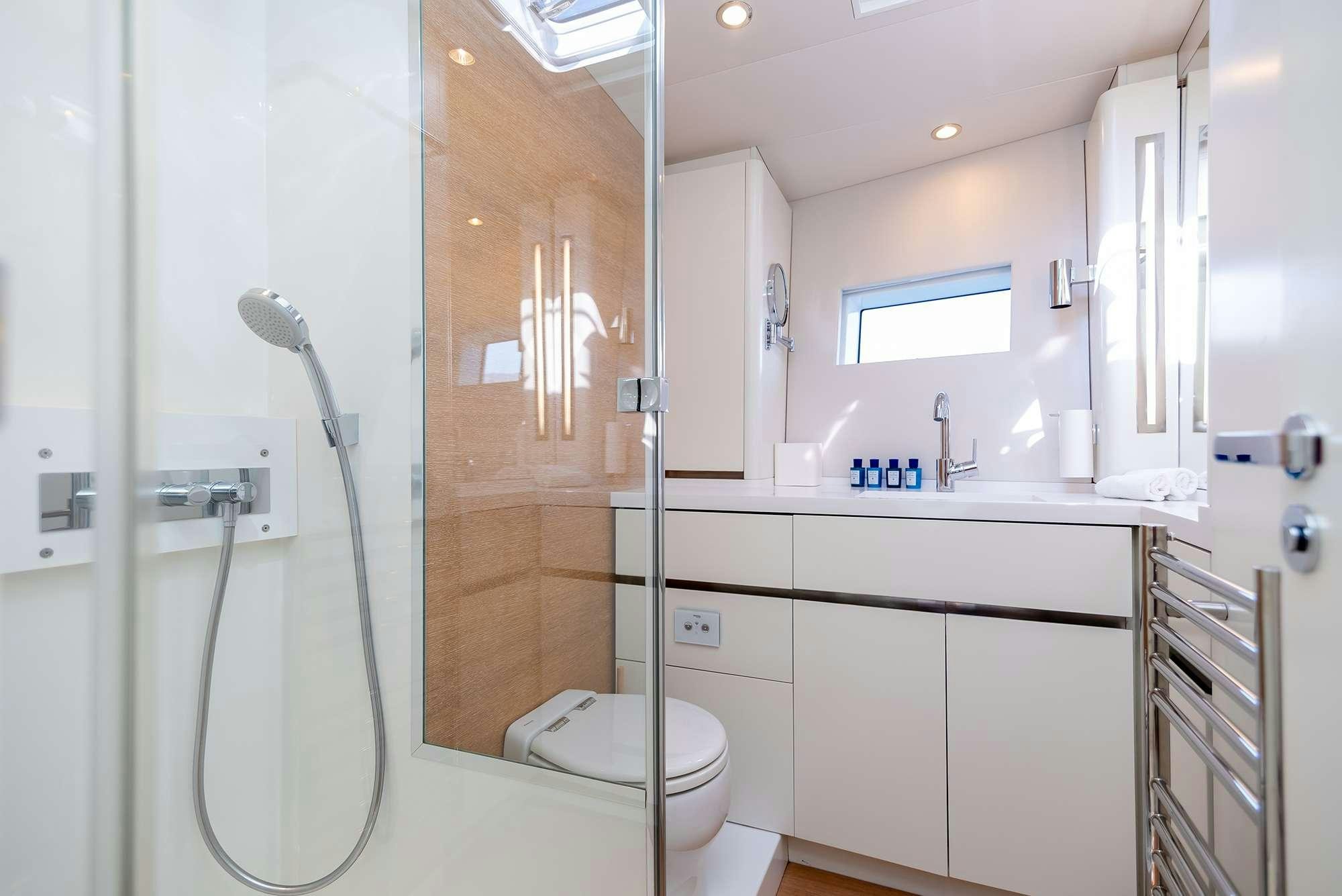 a bathroom with a shower unit and a toilet aboard BUBBLES Yacht for Charter