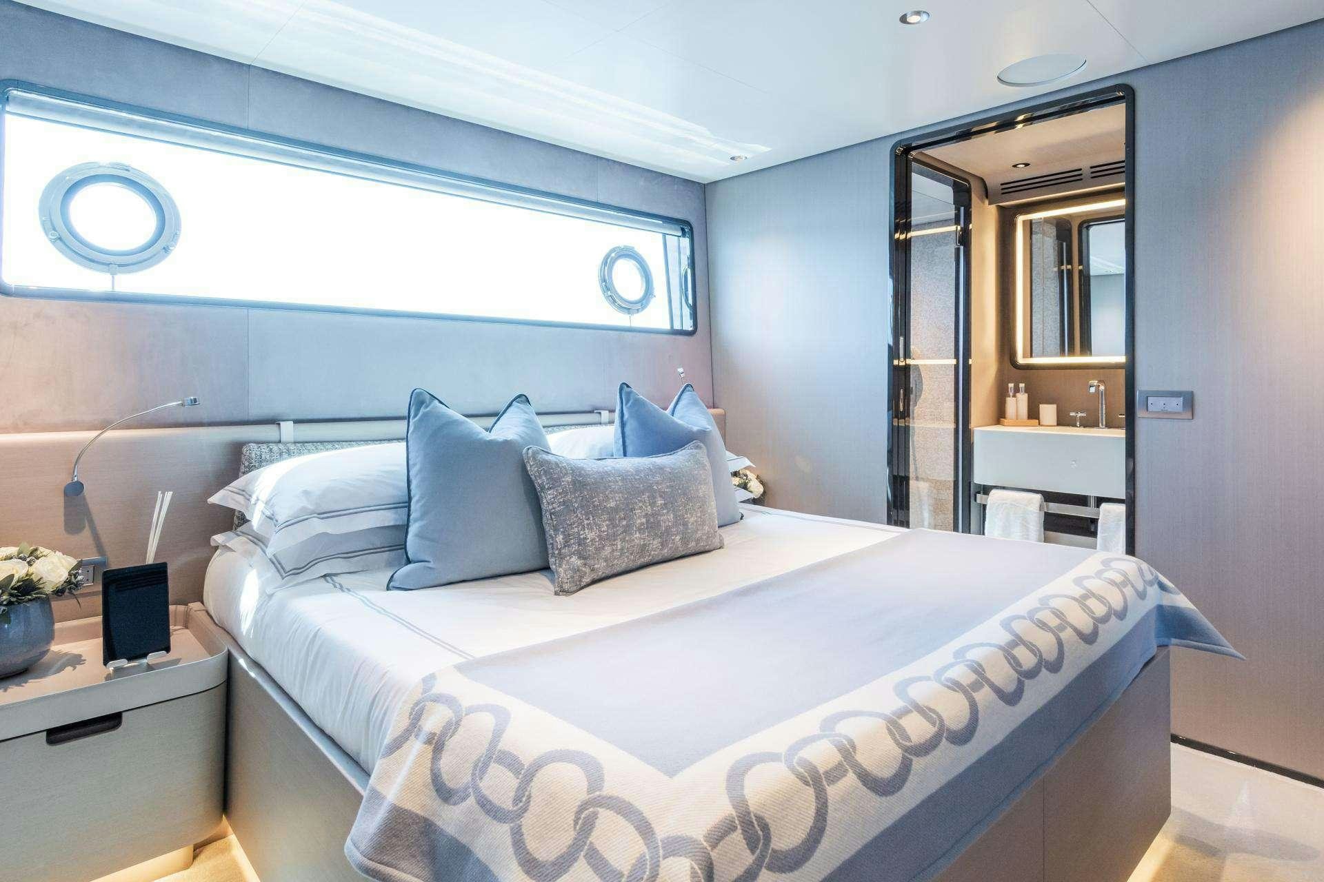 a bed with blue sheets aboard MRS L Yacht for Charter