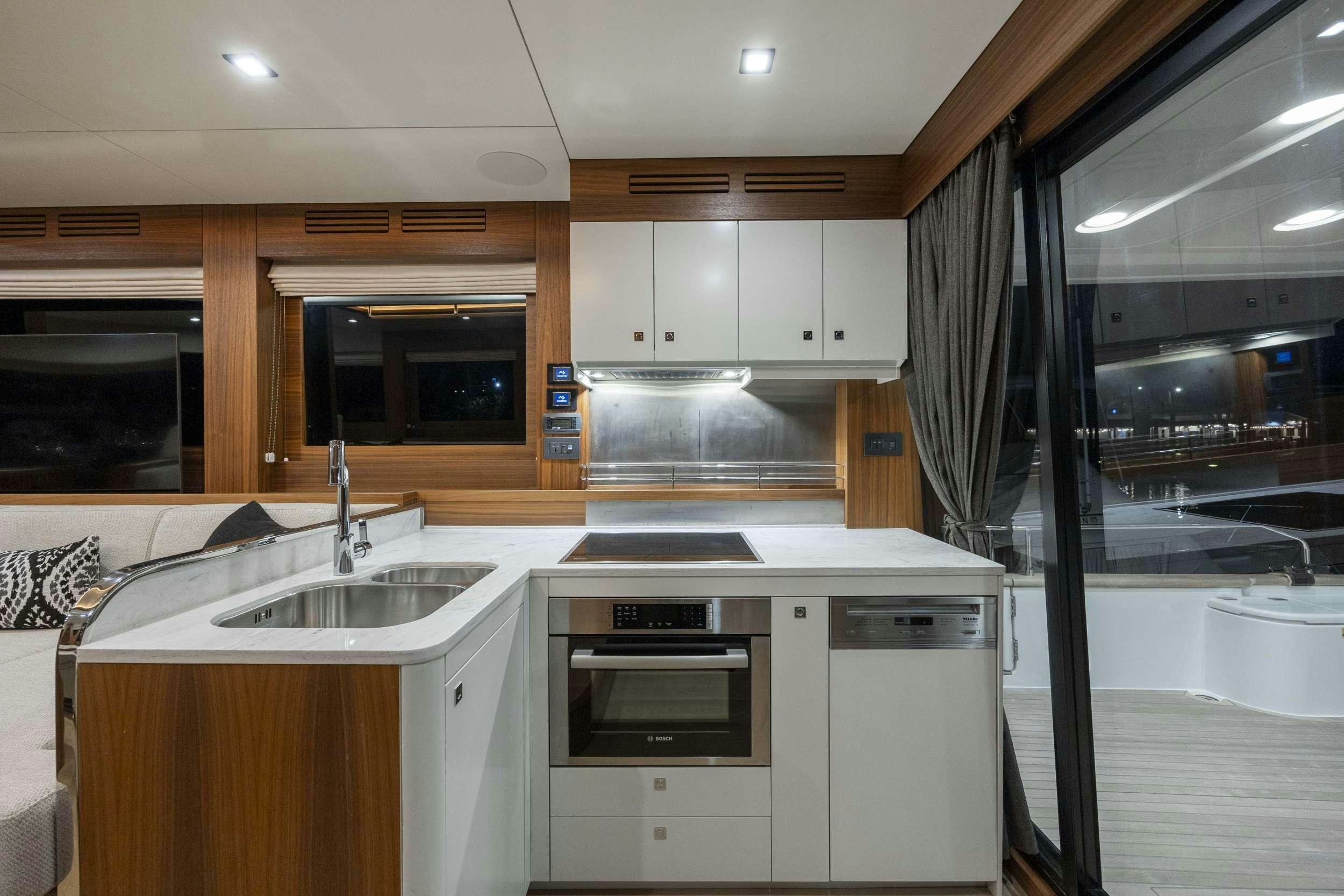 a kitchen with white cabinets aboard OBRIGADA Yacht for Charter