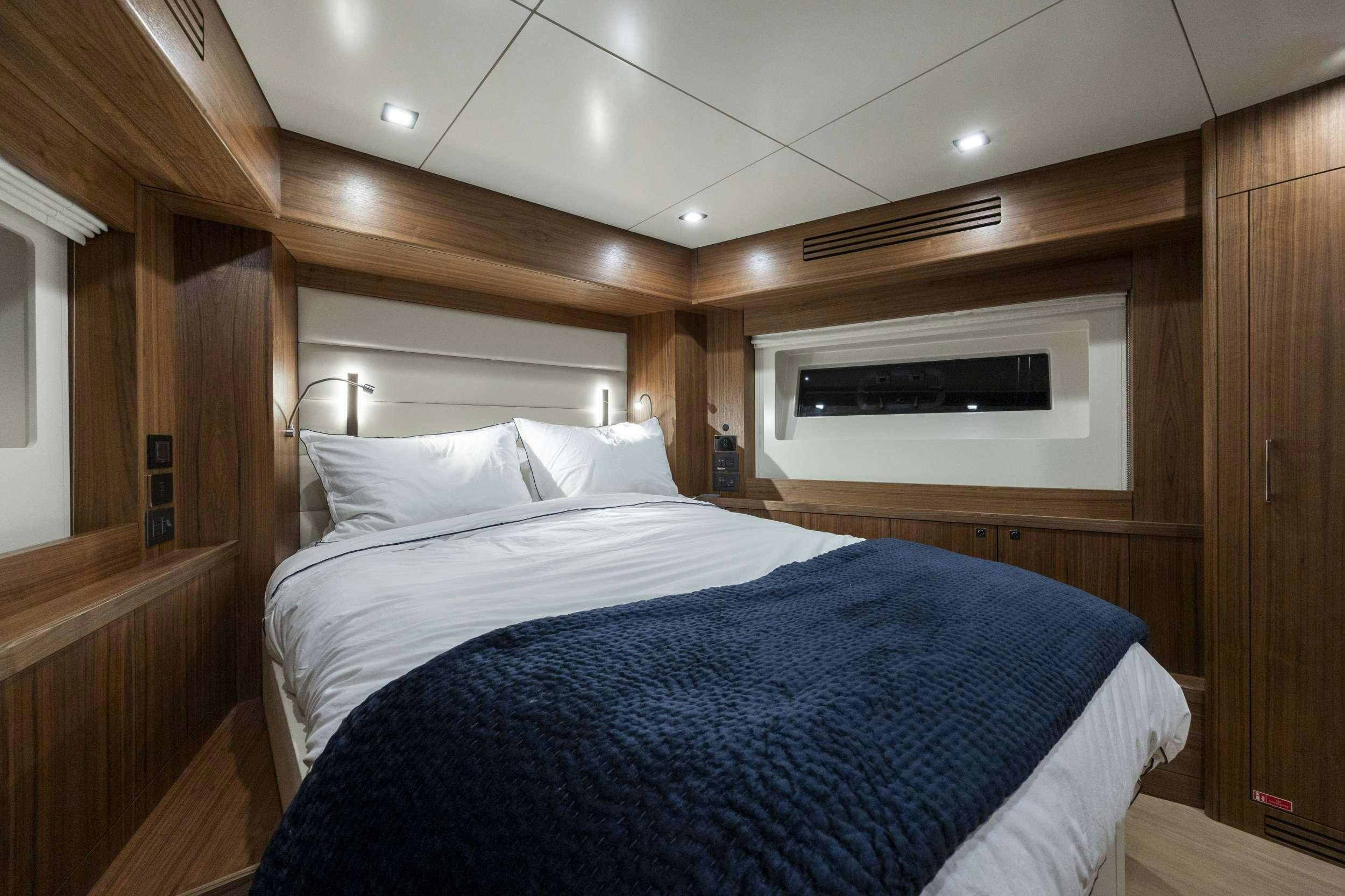 a bedroom with a bed and a television aboard OBRIGADA Yacht for Charter