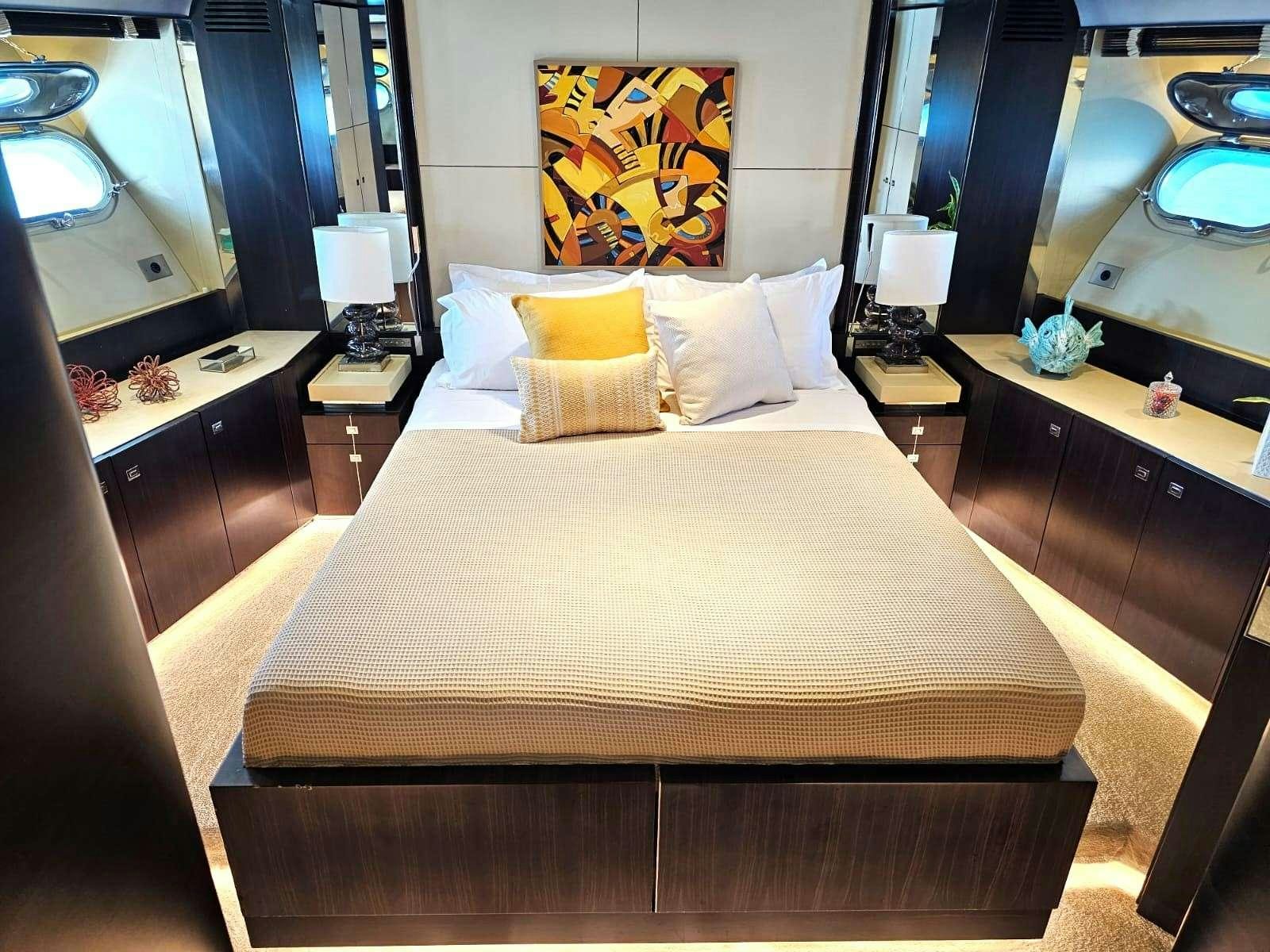 a bed with a white comforter and pillows in a hotel room aboard MAC Yacht for Charter