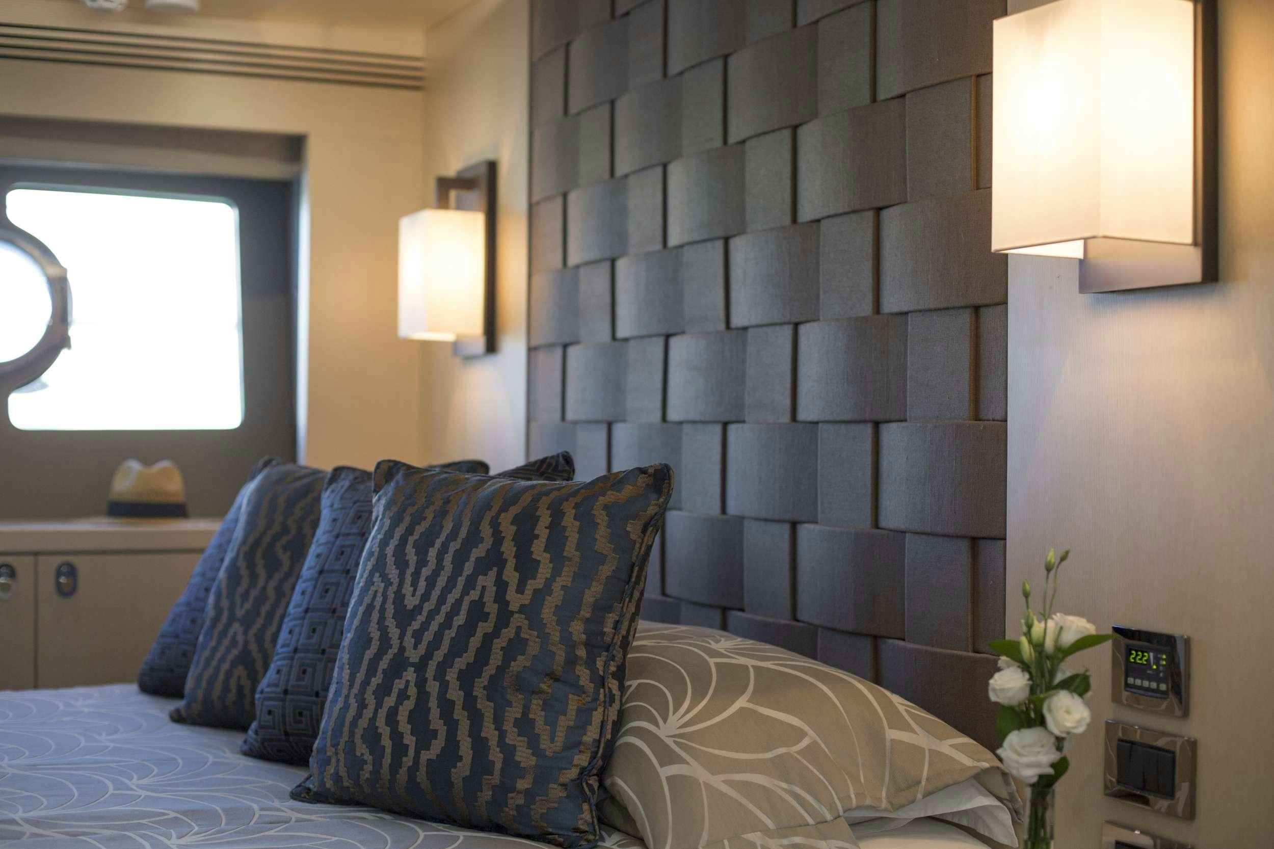 a bed with pillows and a flower aboard FINEZZA Yacht for Charter