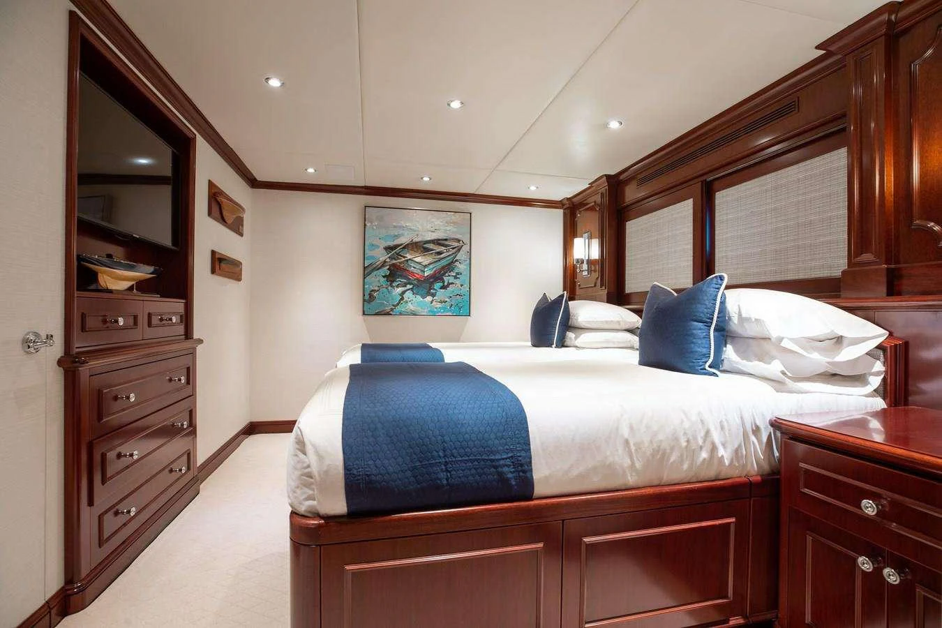 a bedroom with a bed and dresser aboard BOUCHON Yacht for Charter