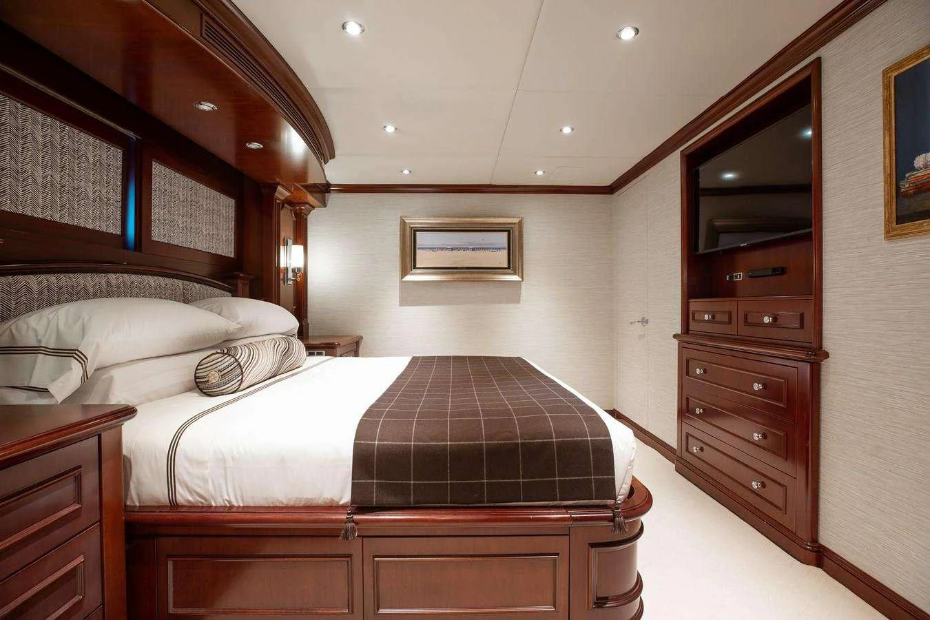 a bedroom with a bed and a dresser aboard BOUCHON Yacht for Charter