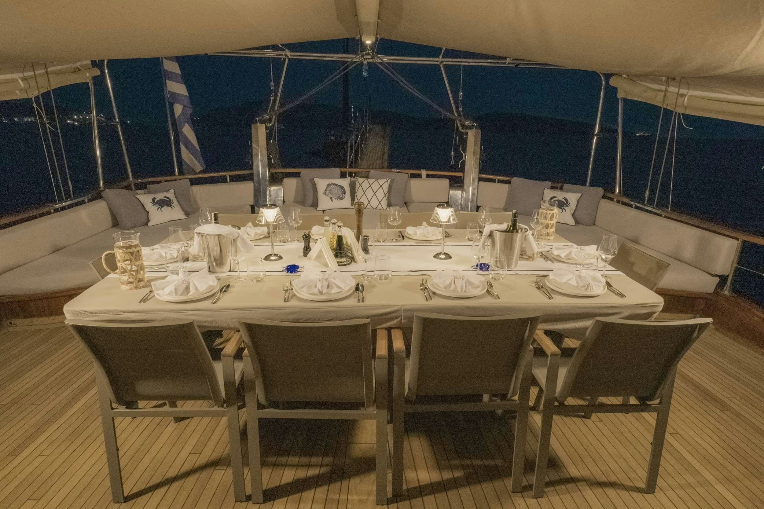 a table set for a dinner party aboard 105 MOTOR Yacht for Charter