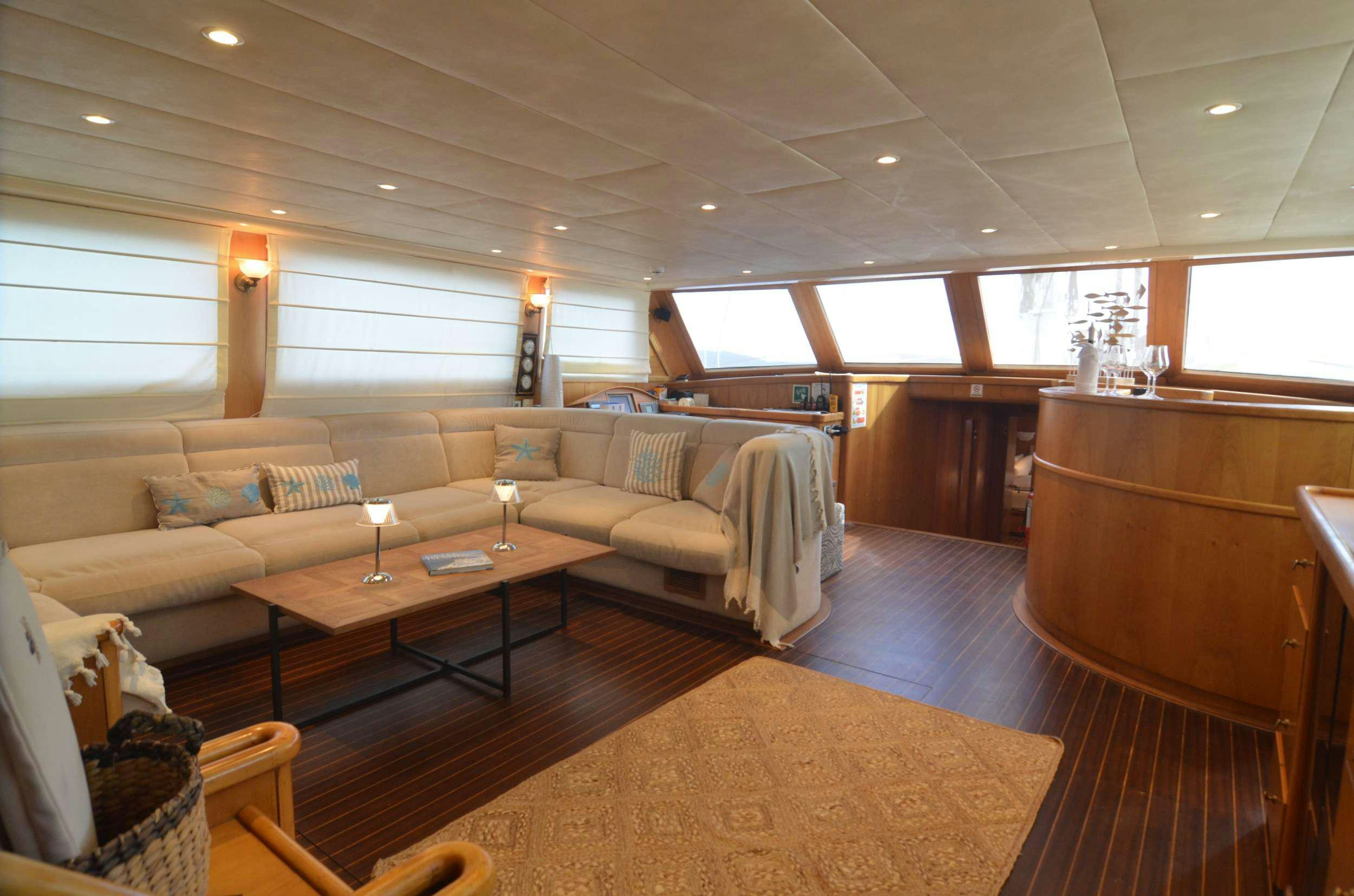 a living room with a couch and a coffee table aboard 105 MOTOR Yacht for Charter