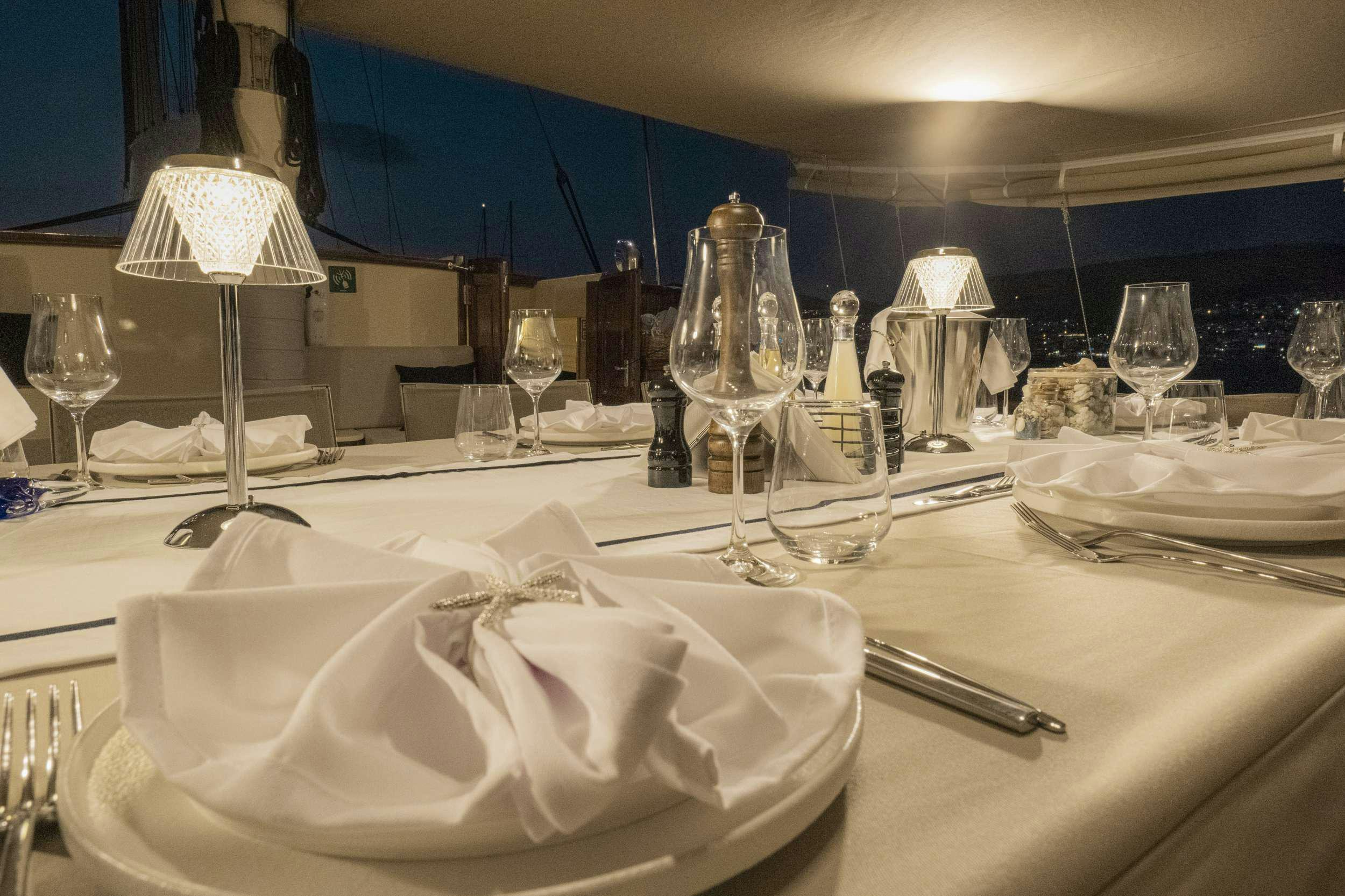 a table with plates and glasses aboard 105 MOTOR Yacht for Charter