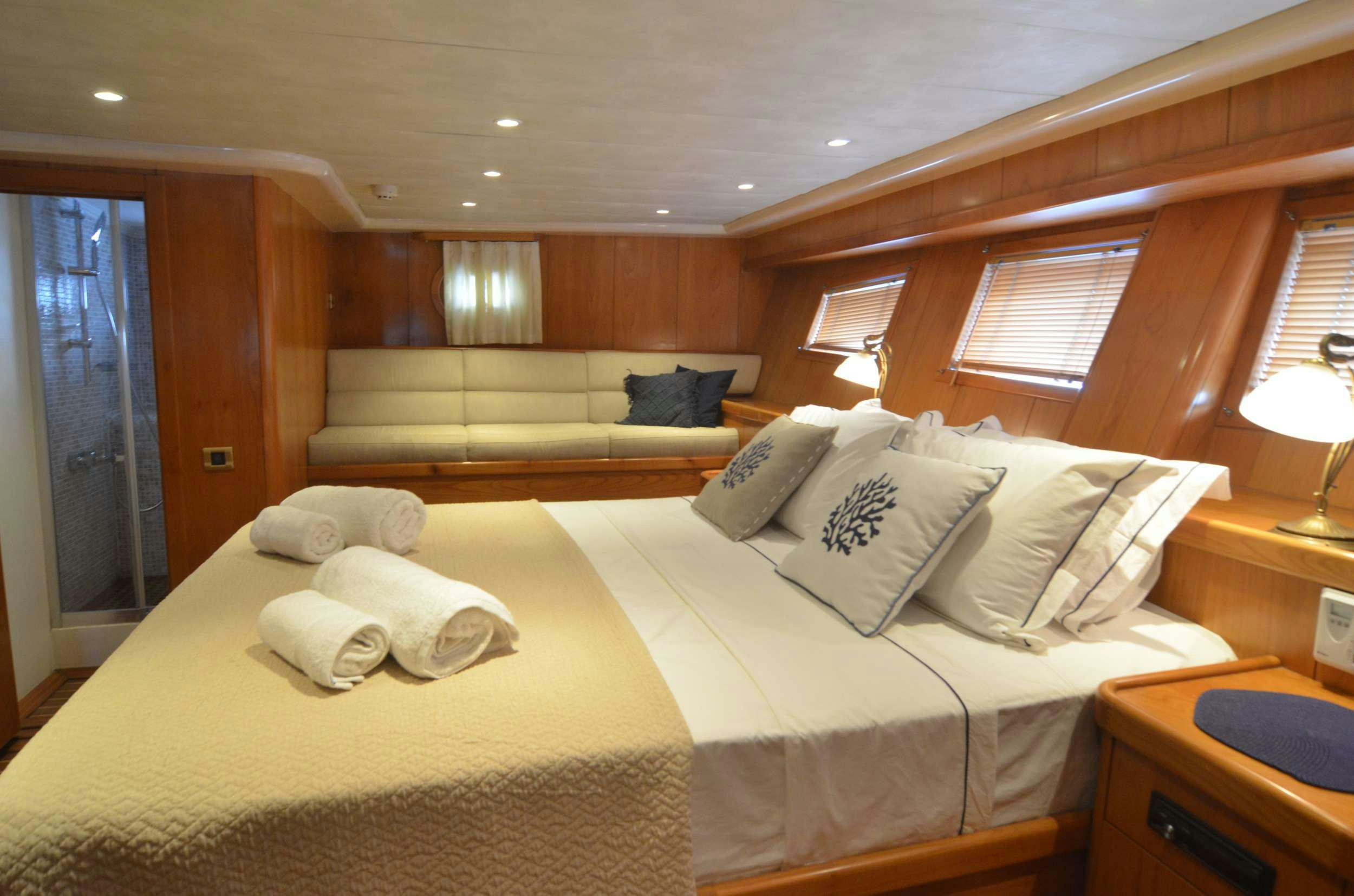 a bed with a white sheet and pillows on it aboard 105 MOTOR Yacht for Charter