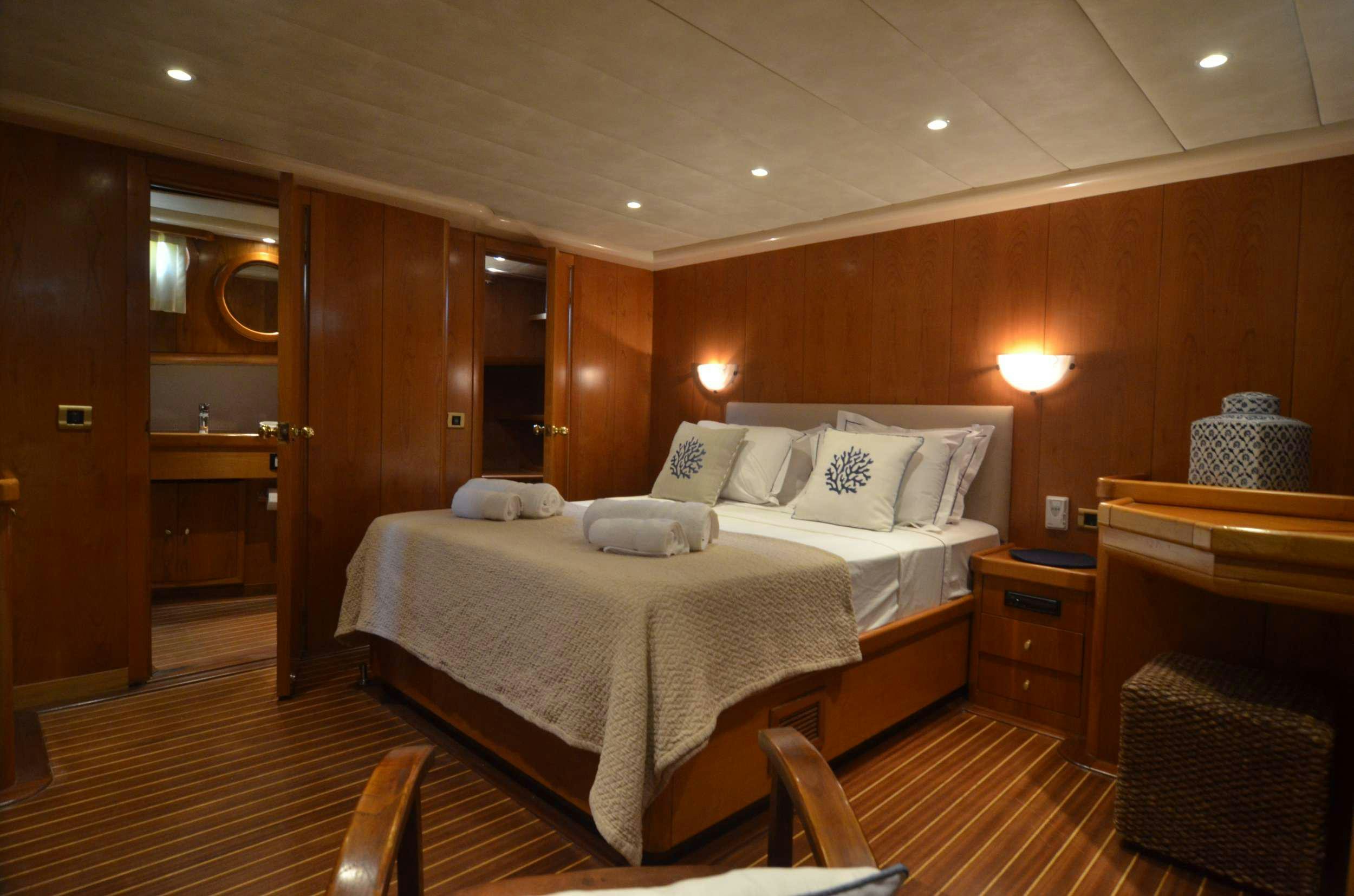 a room with a bed and a mirror aboard 105 MOTOR Yacht for Charter