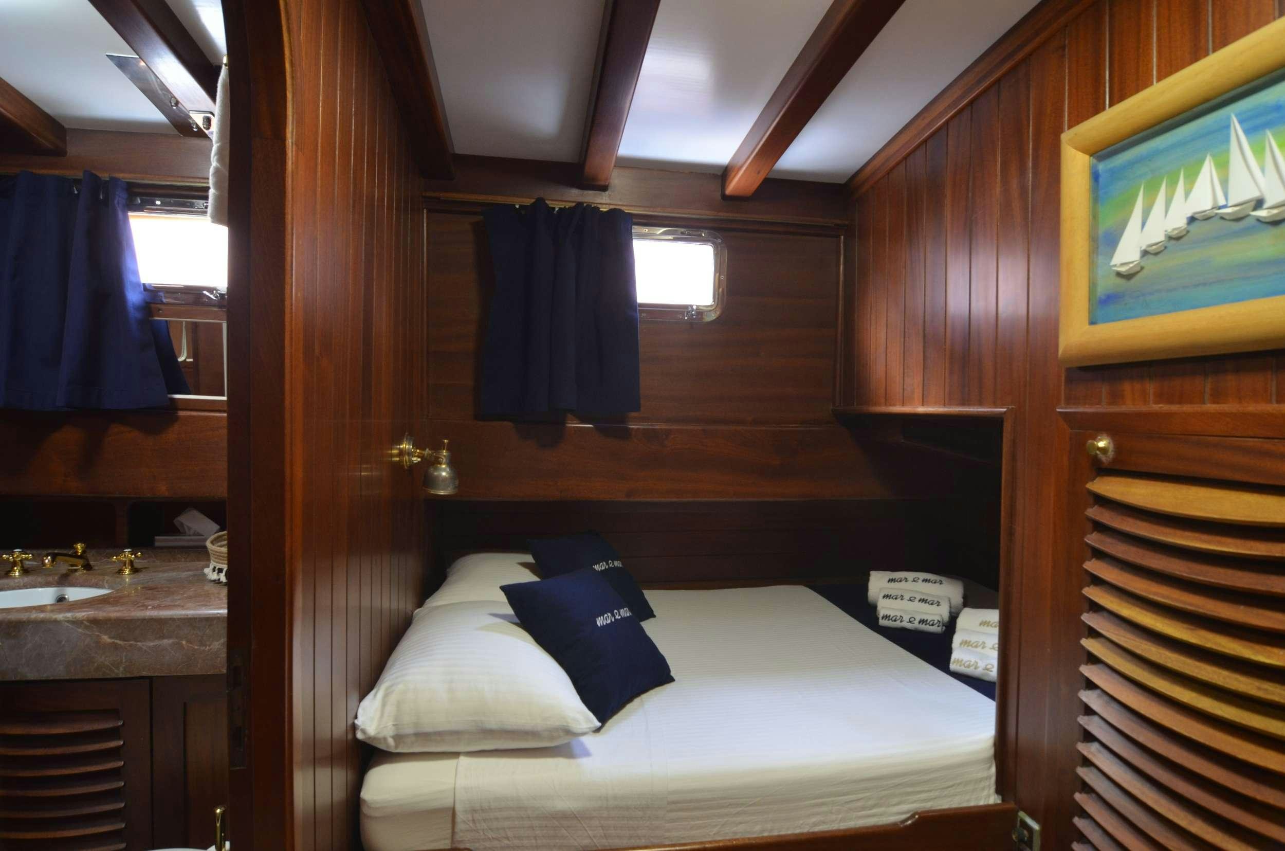 a room with a bed and a television aboard MAR E MAR Yacht for Charter