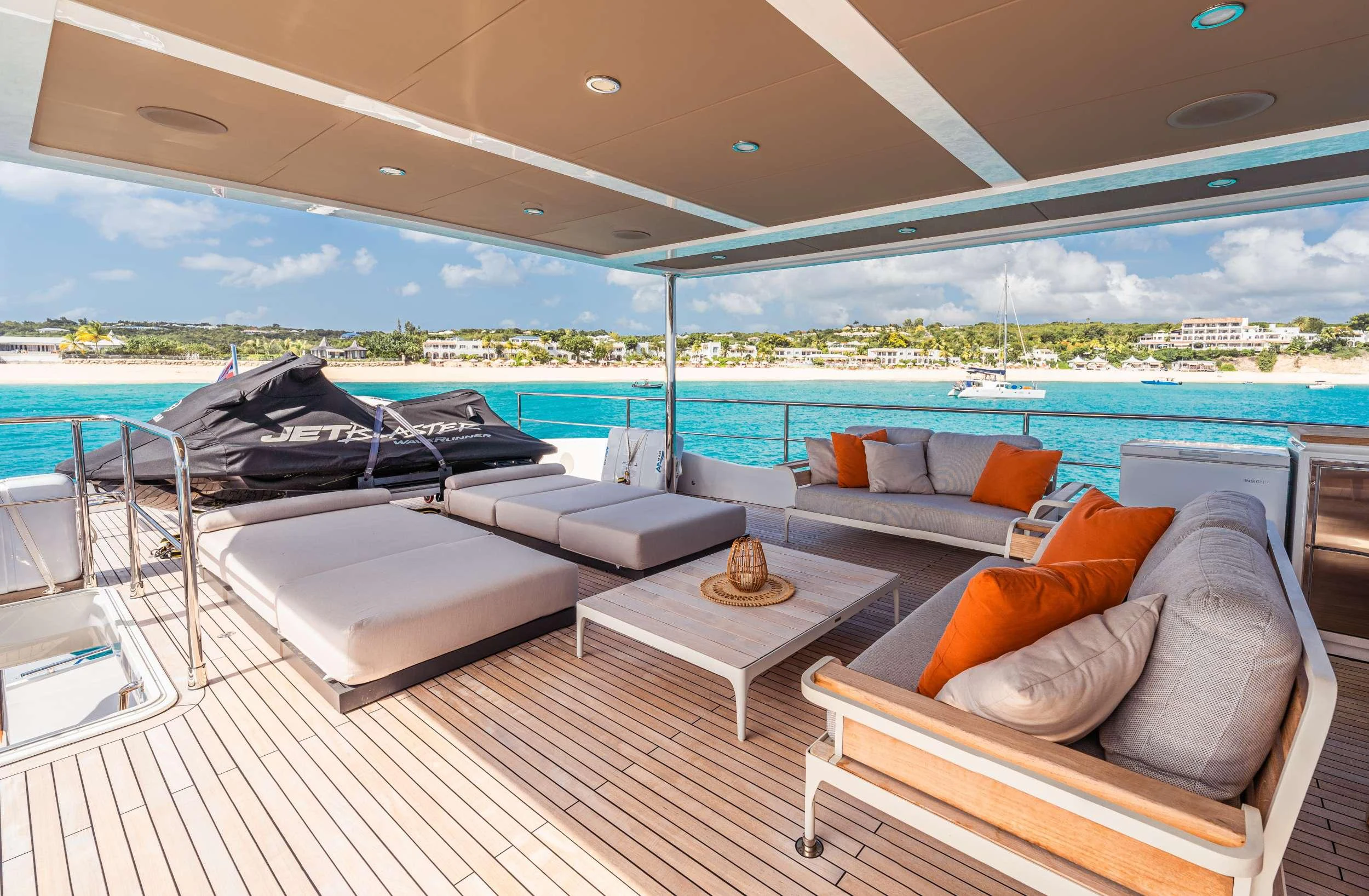 a lounge area with a bed and a large body of water aboard EXIT STRATEGY Yacht for Charter