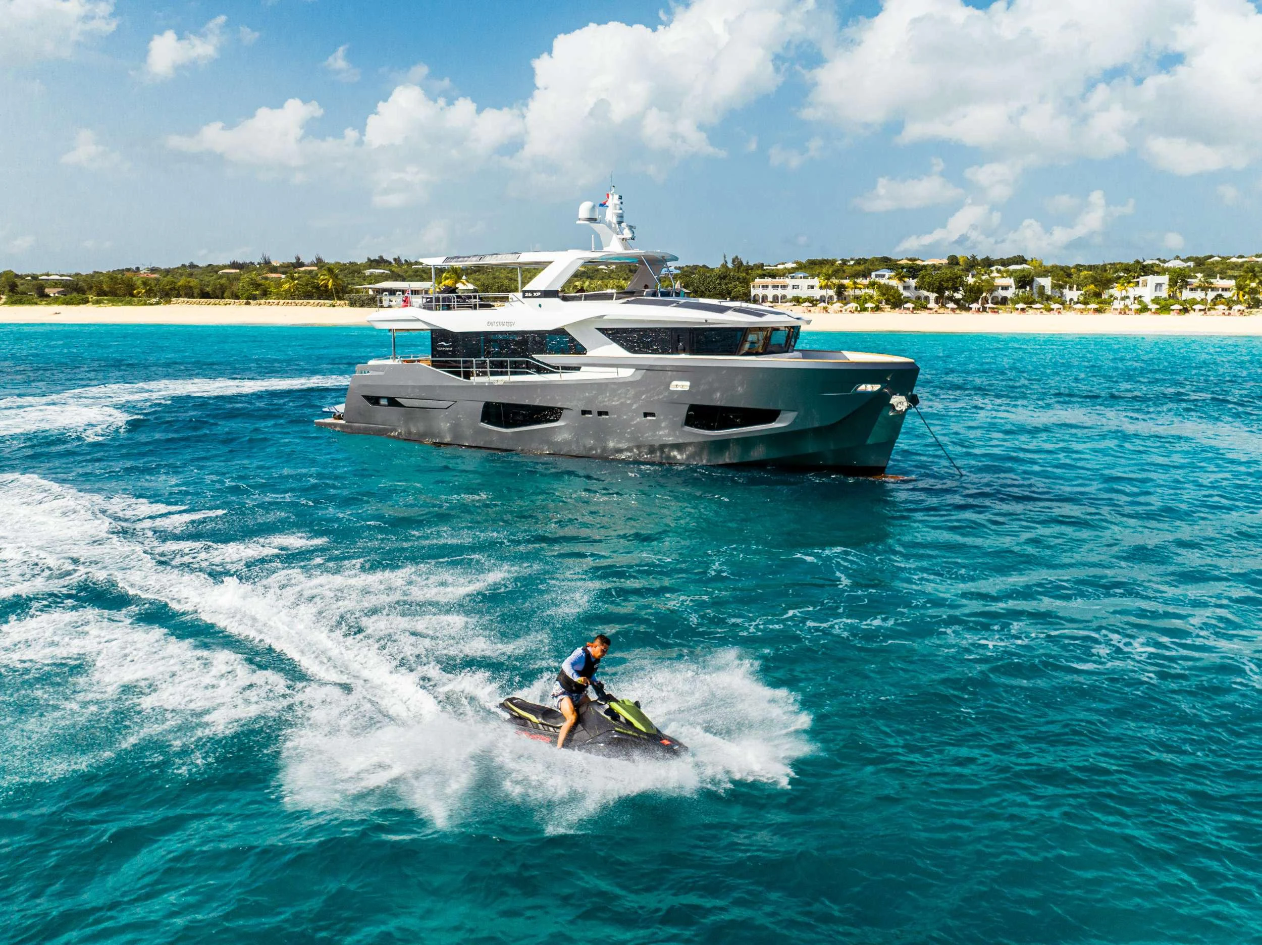 a man on a jet ski in the water next to a boat aboard EXIT STRATEGY Yacht for Charter
