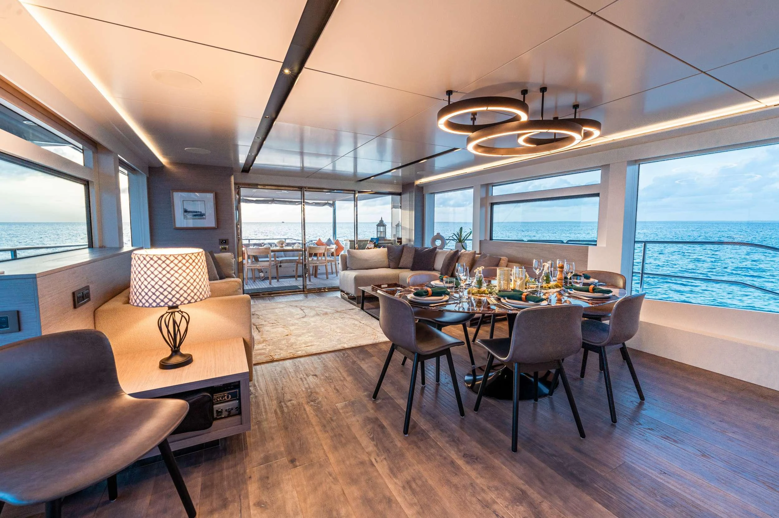a large living room with a large table and chairs aboard EXIT STRATEGY Yacht for Charter