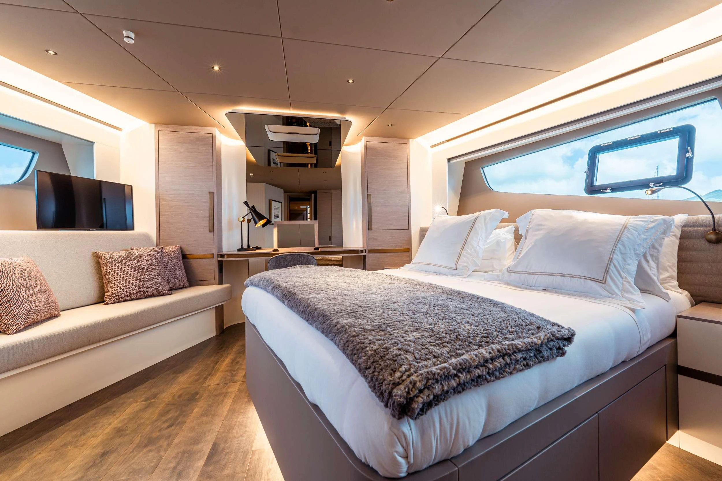 a bedroom with a bed and a couch aboard EXIT STRATEGY Yacht for Charter