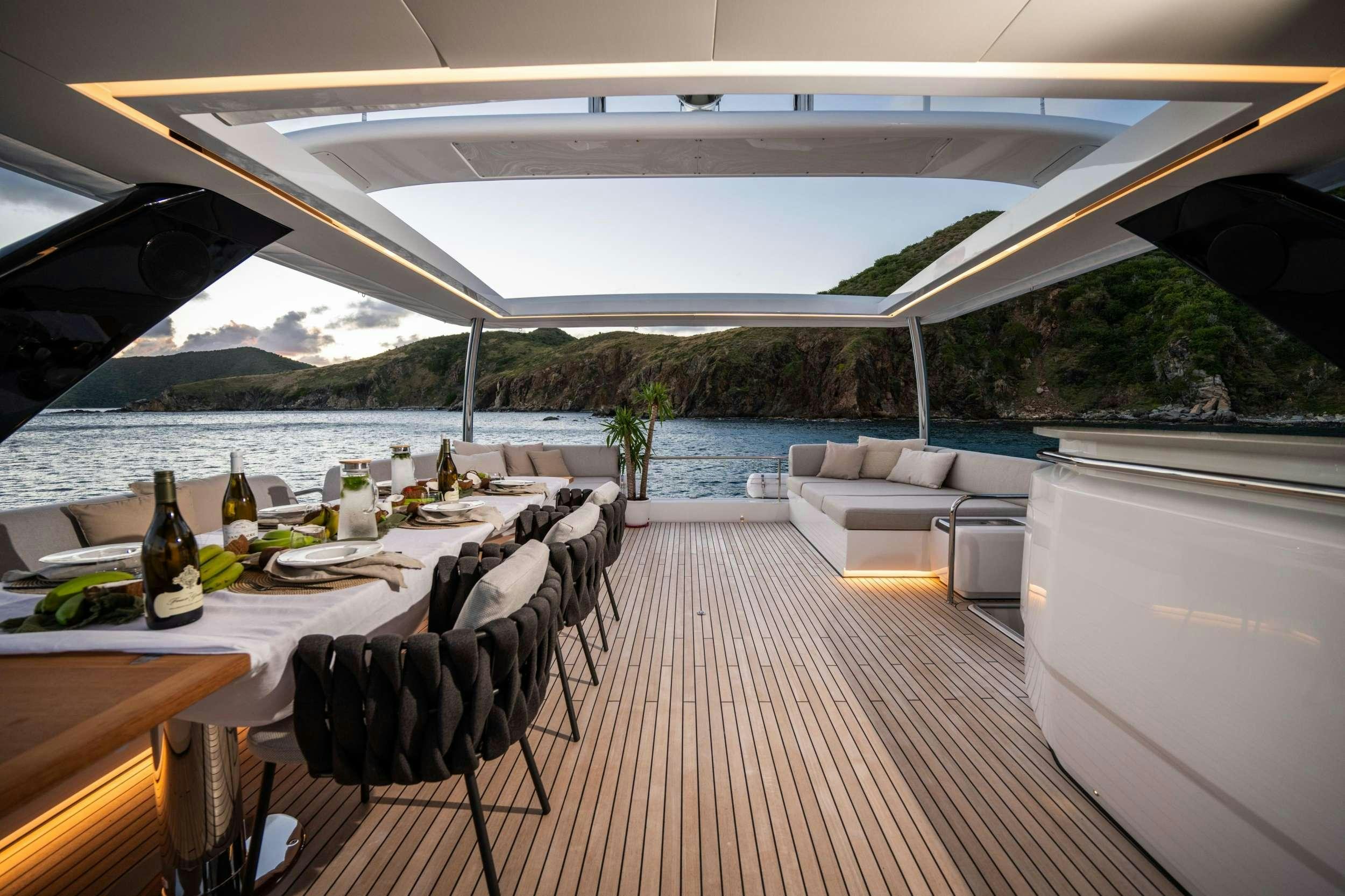 a large patio with a table and chairs and a large body of water aboard SIETE MARES Yacht for Charter