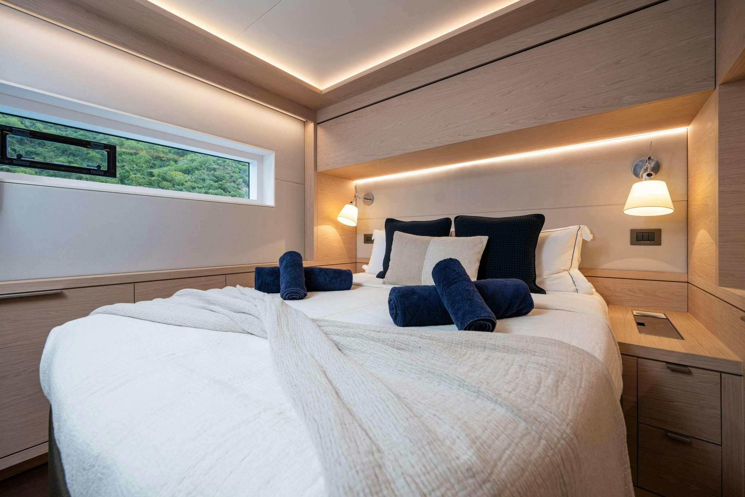 a bed with a white bed spread aboard SIETE MARES Yacht for Charter