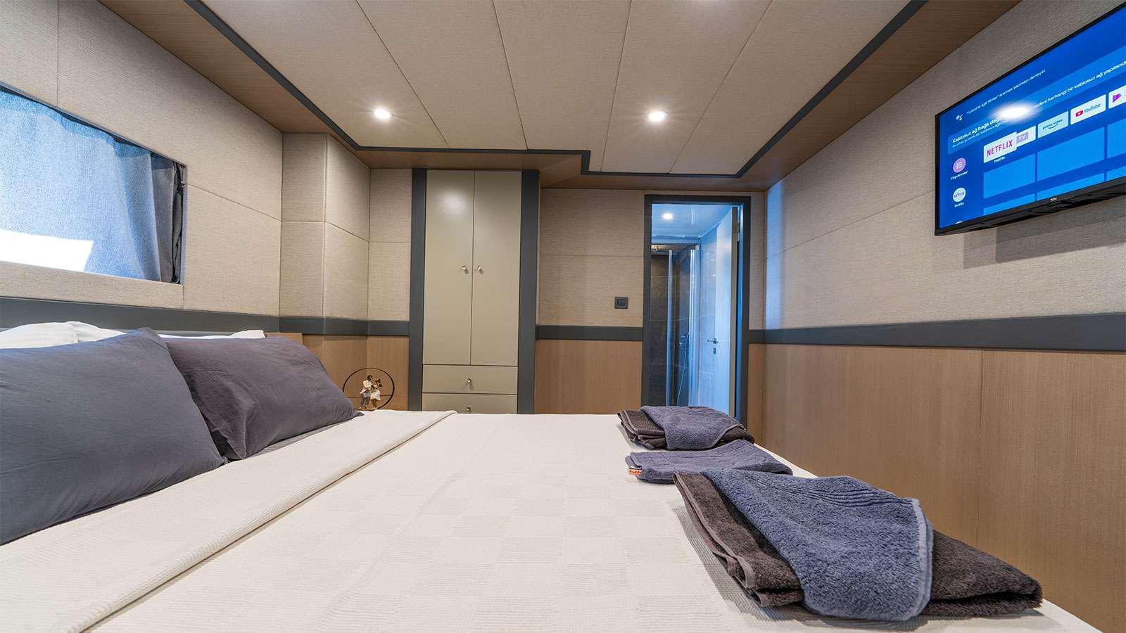 a room with a bed and a tv on the wall aboard ALBATROS K Yacht for Charter
