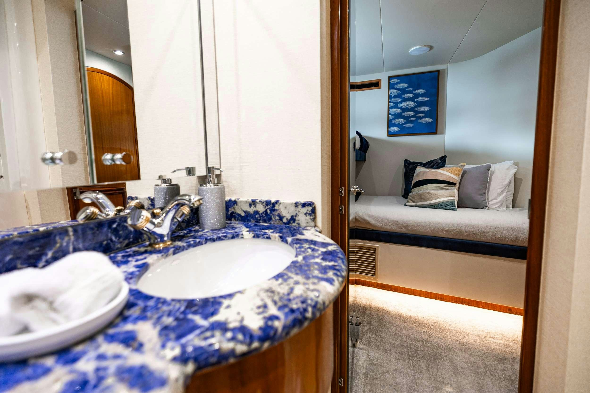 a bathroom with a sink and a bed aboard INDY Yacht for Charter