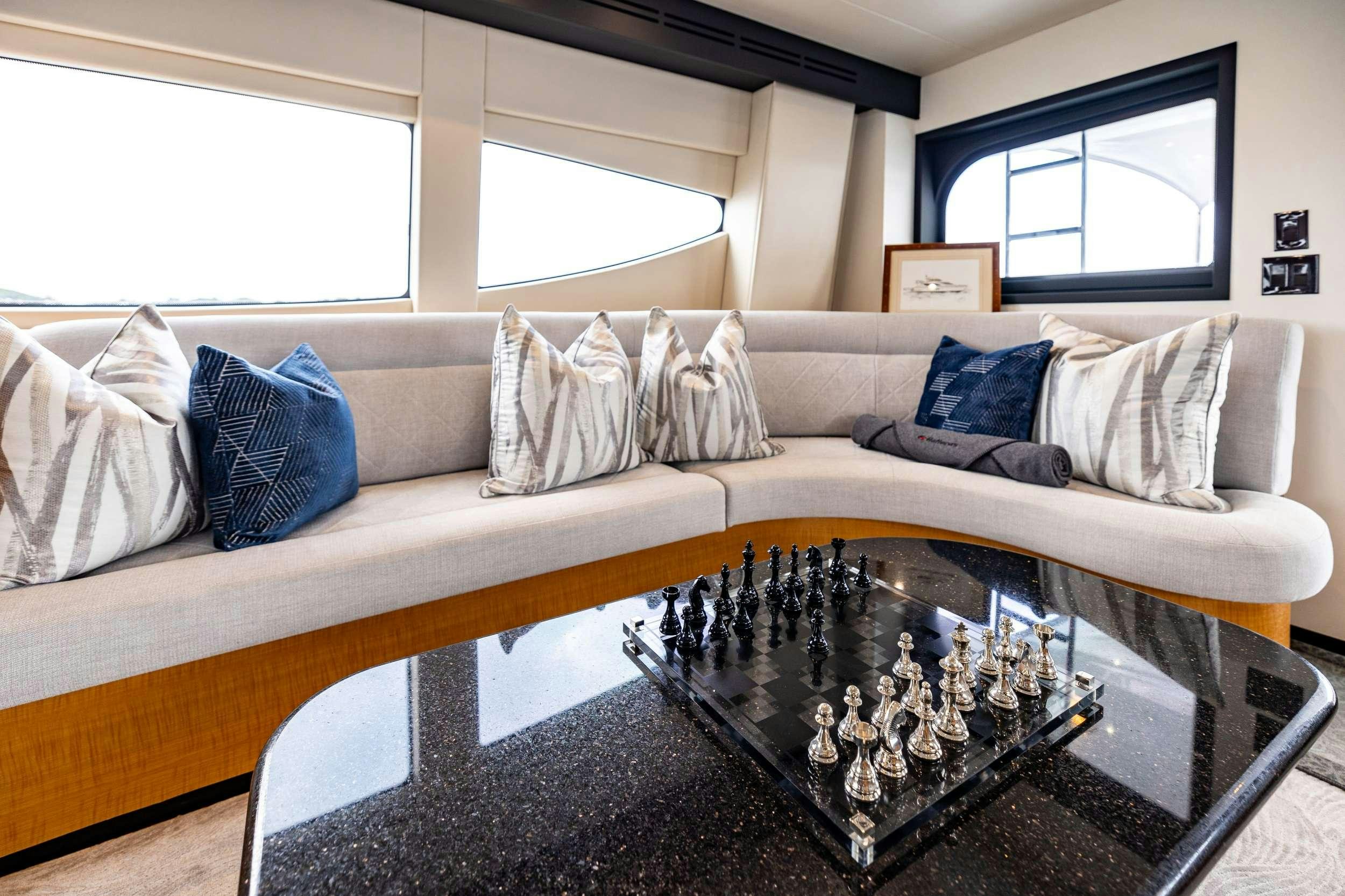 a living room with a large sectional sofa and a coffee table aboard INDY Yacht for Charter