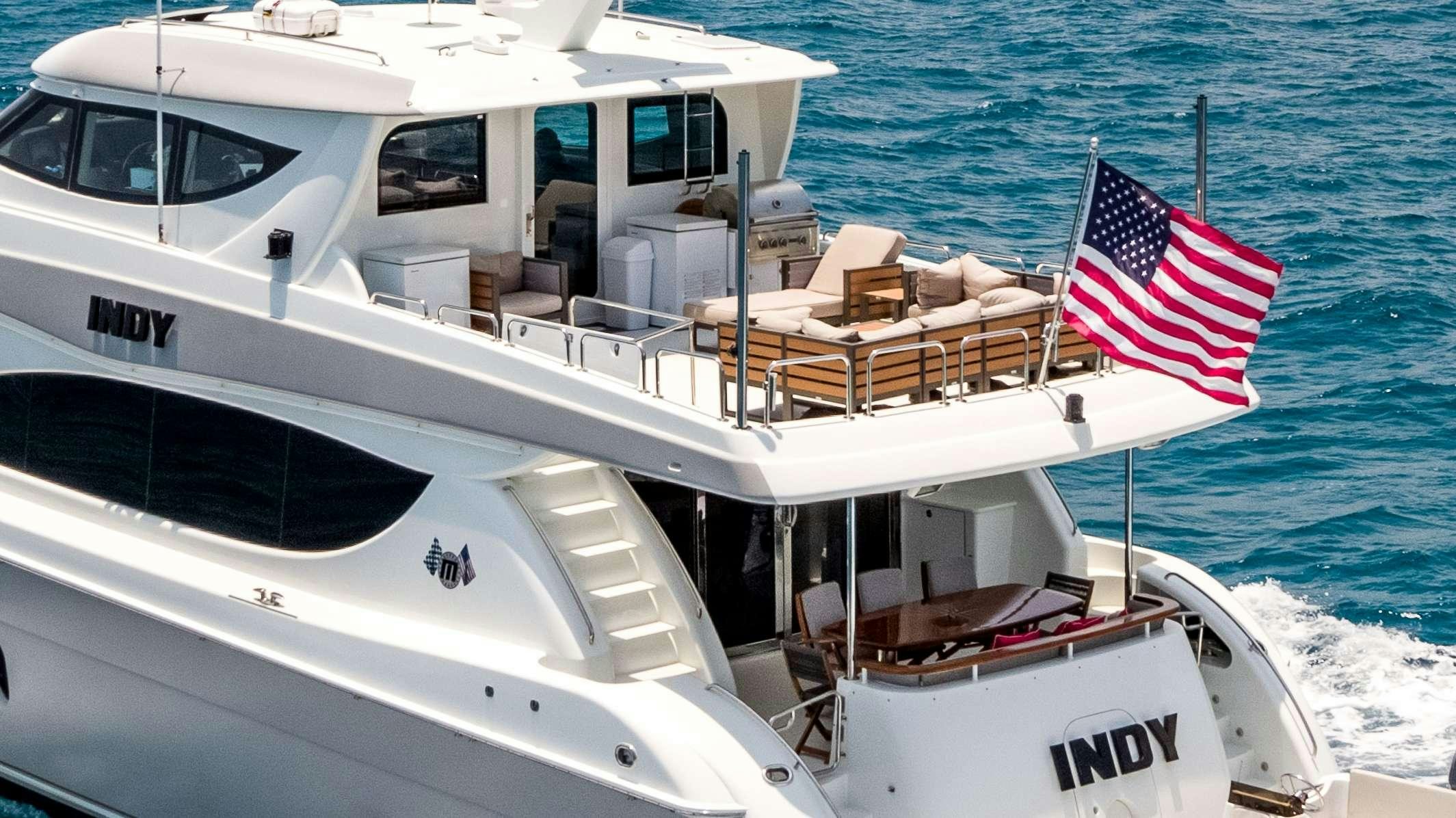 a boat with a flag on the front aboard INDY Yacht for Charter