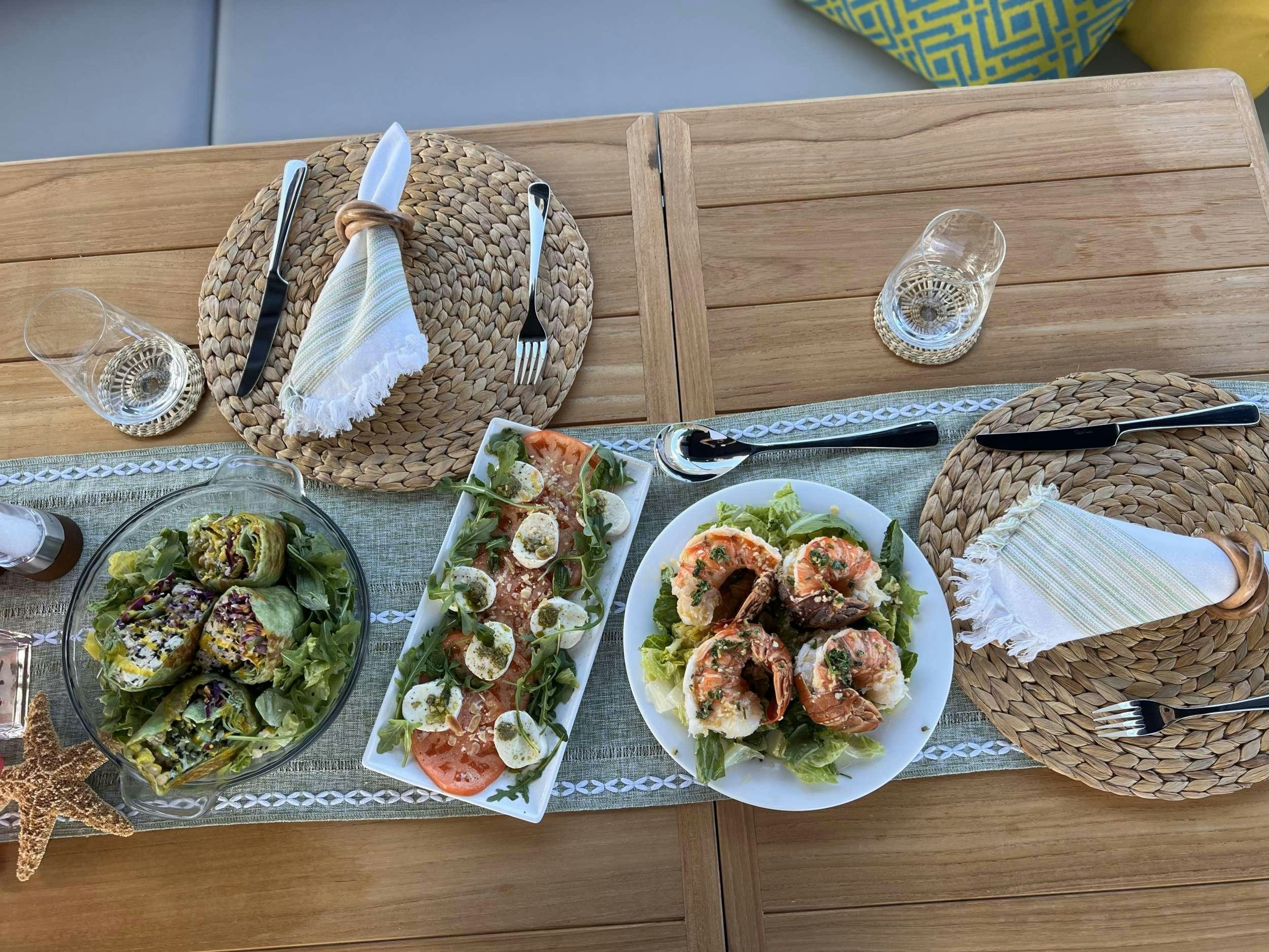 a table with plates of food and silverware aboard ACCIDENTAL SUCCESS II Yacht for Charter