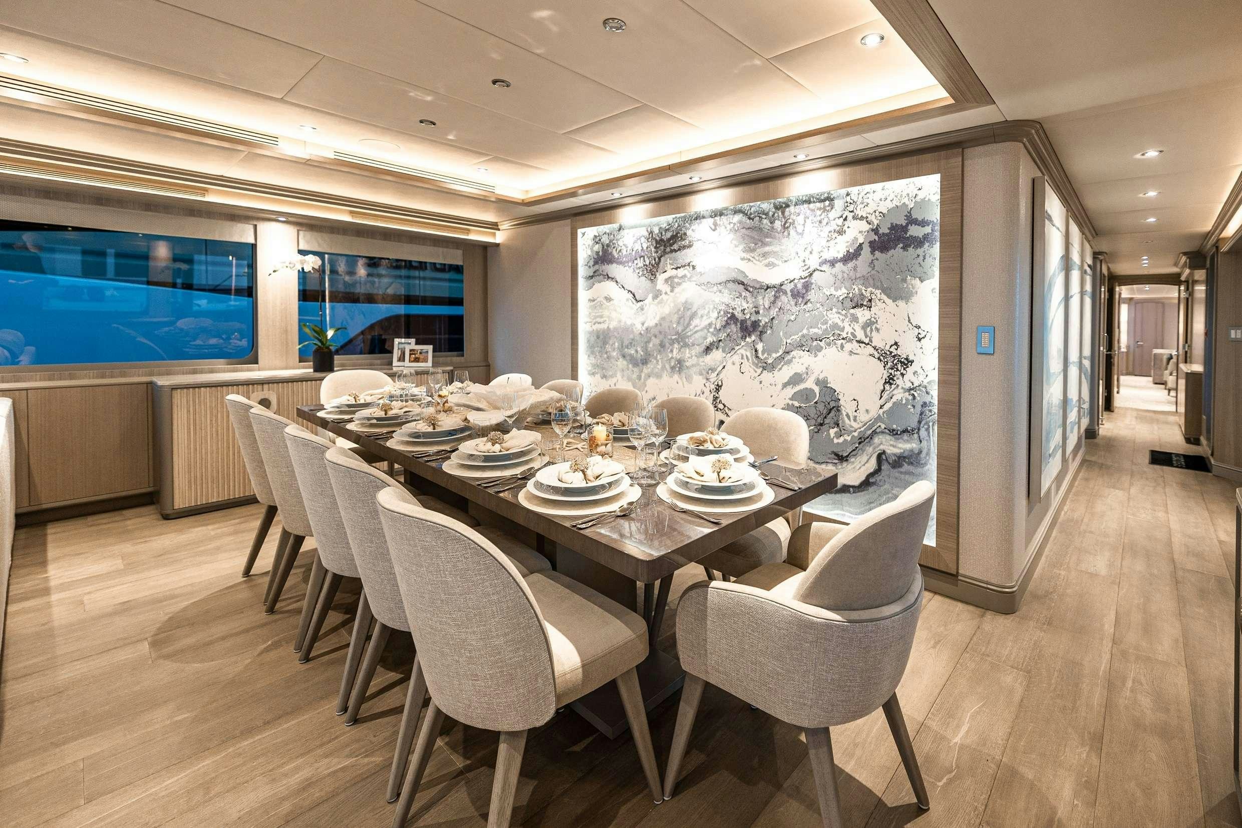 a large dining room with a large screen aboard NO BAD IDEAS Yacht for Charter