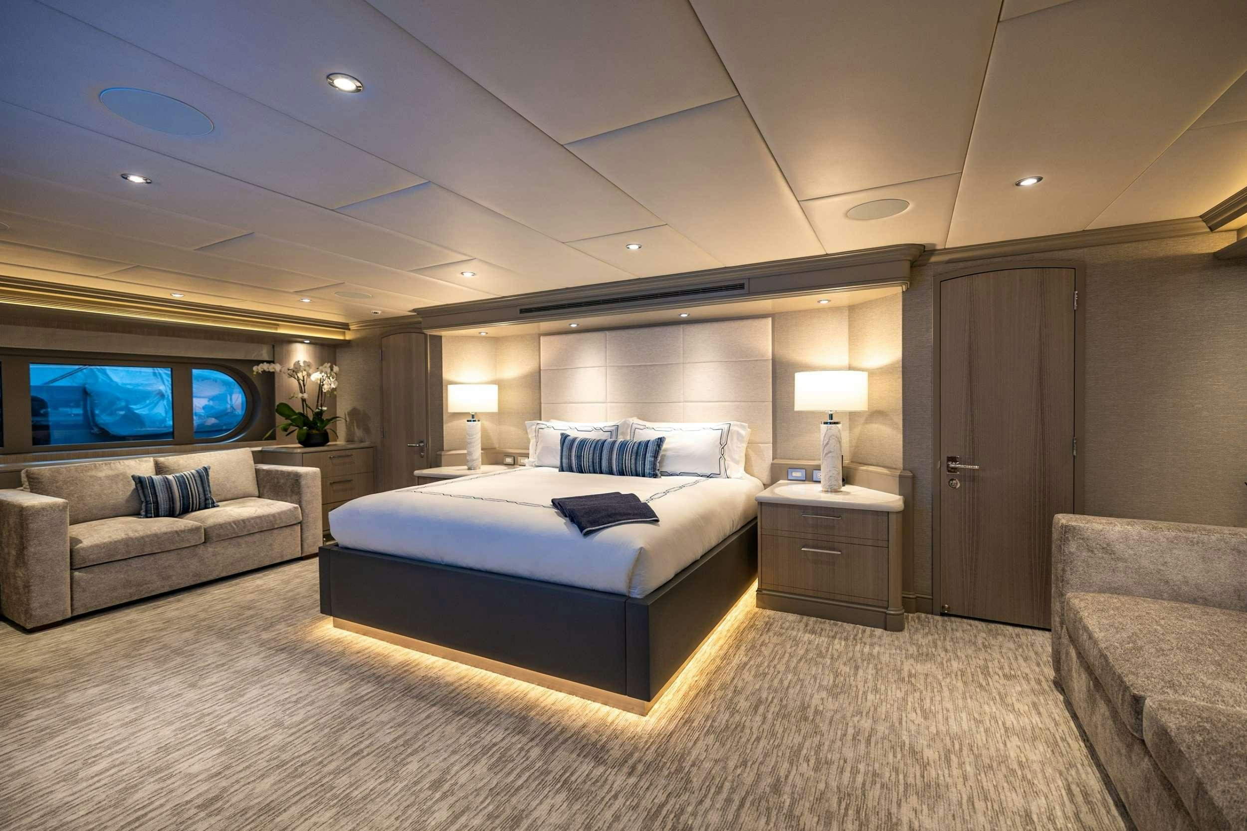 a large bedroom with a bed and a couch aboard NO BAD IDEAS Yacht for Charter
