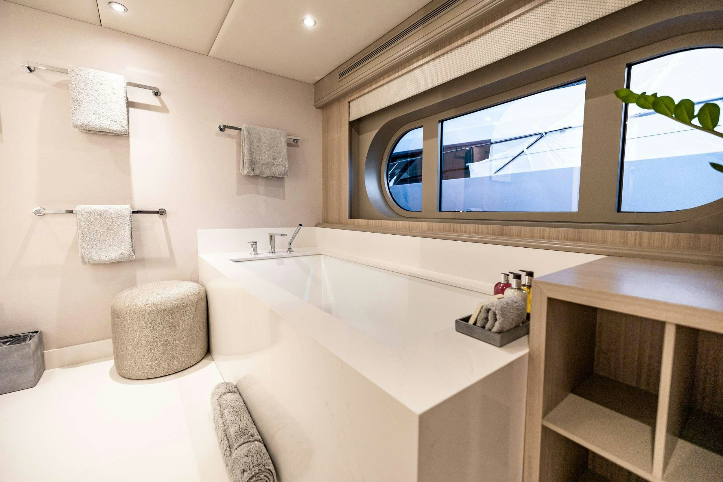 a bathroom with a tub sink and a mirror aboard NO BAD IDEAS Yacht for Charter
