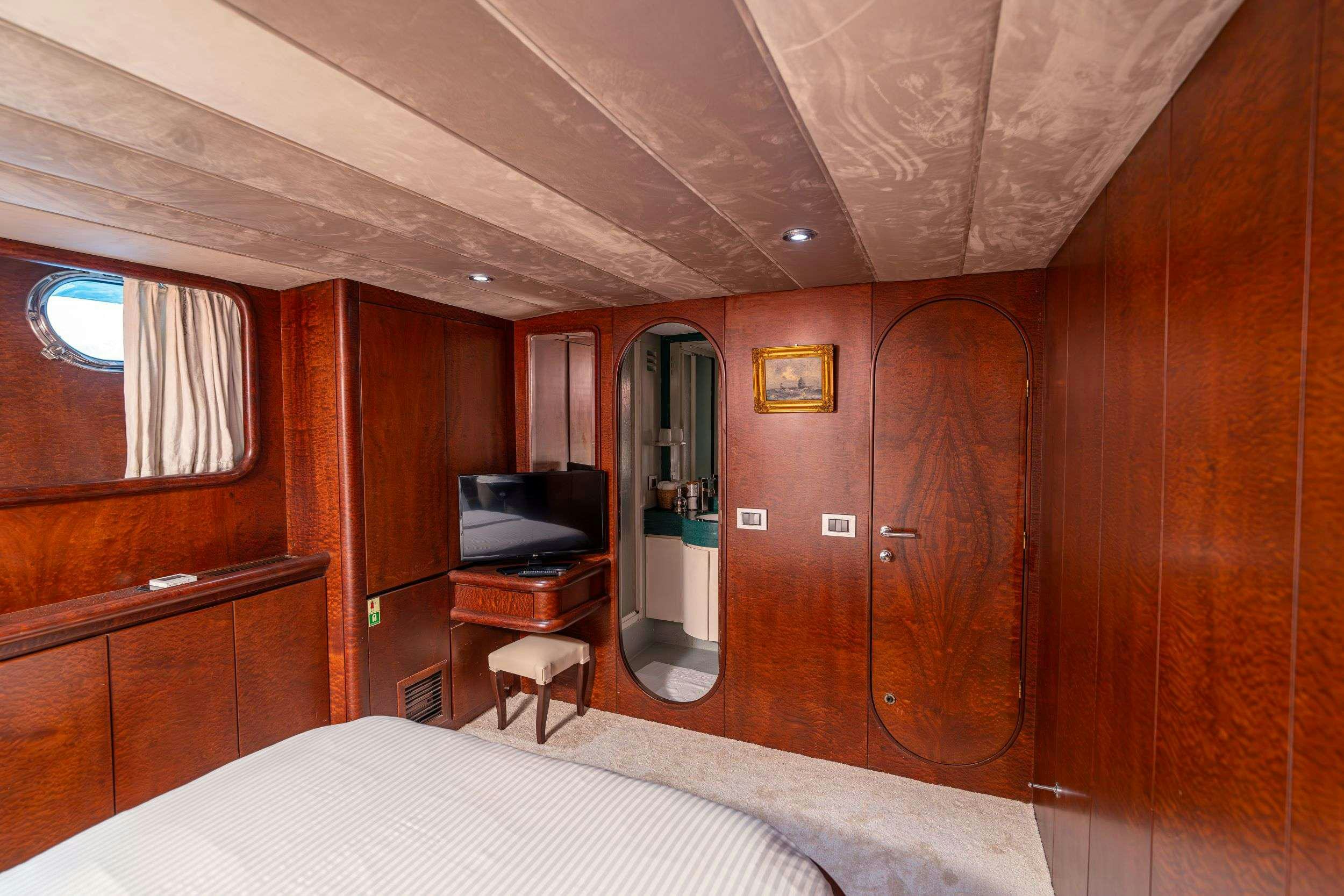 a bedroom with a bed and a desk aboard BLUES Yacht for Charter