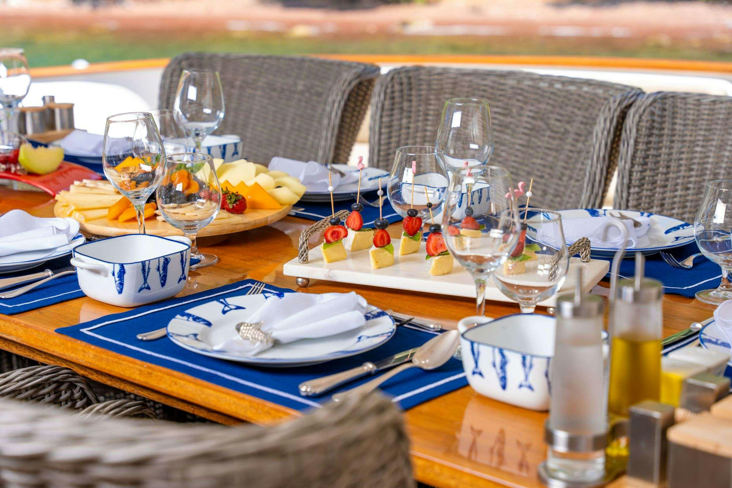 a table with plates and glasses on it aboard BLUES Yacht for Charter