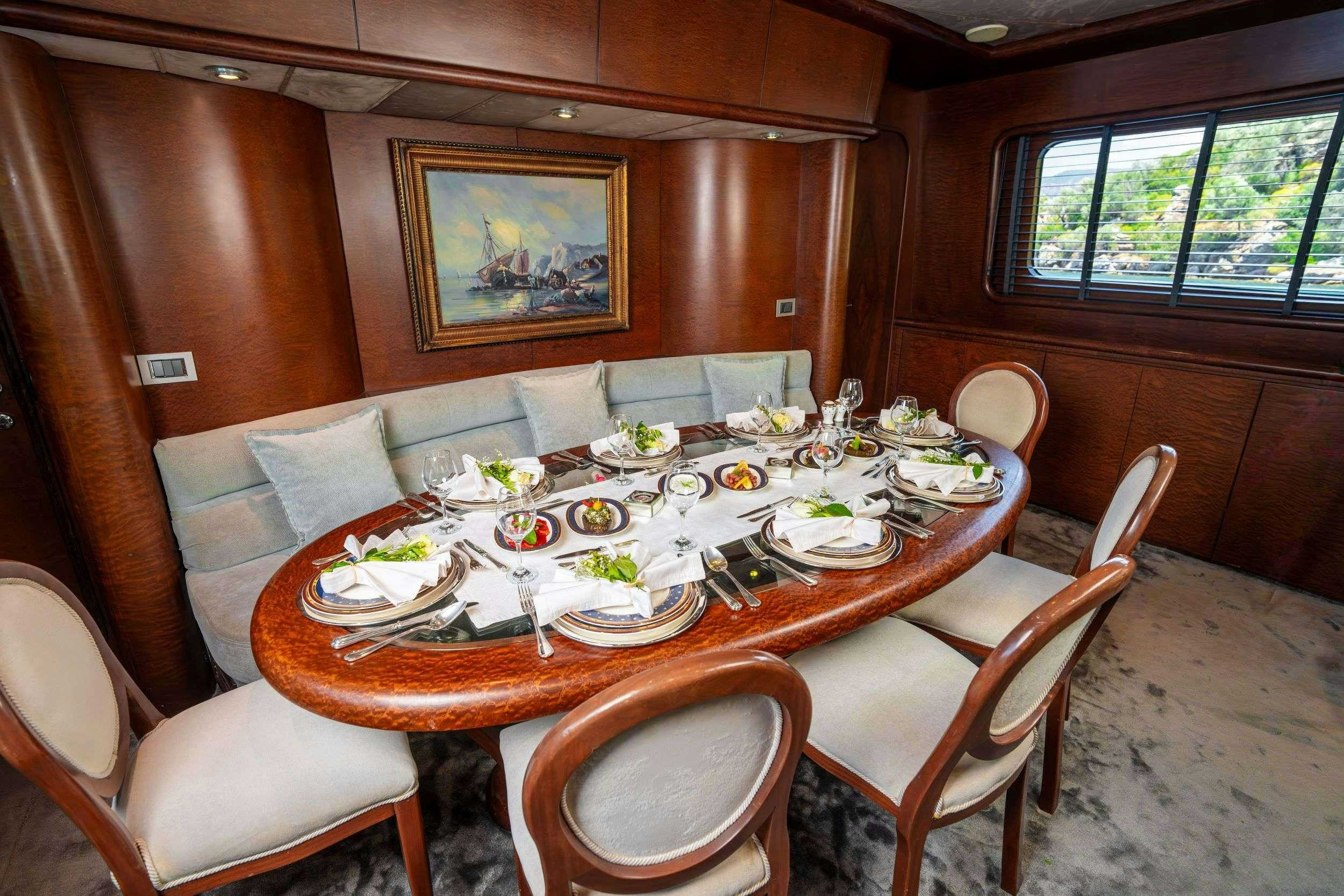 a dining table with plates and chairs aboard BLUES Yacht for Charter