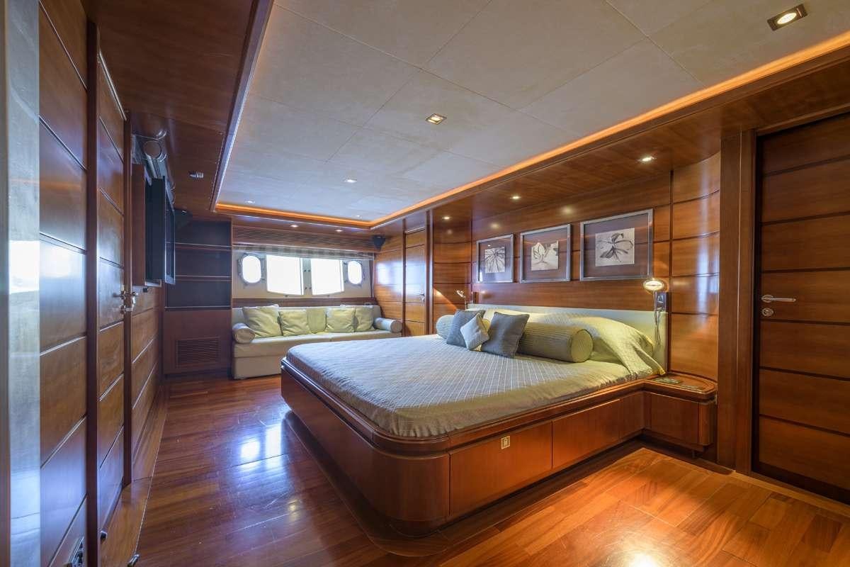 a bedroom with a bed and a wood floor aboard ANNE MARIE Yacht for Charter