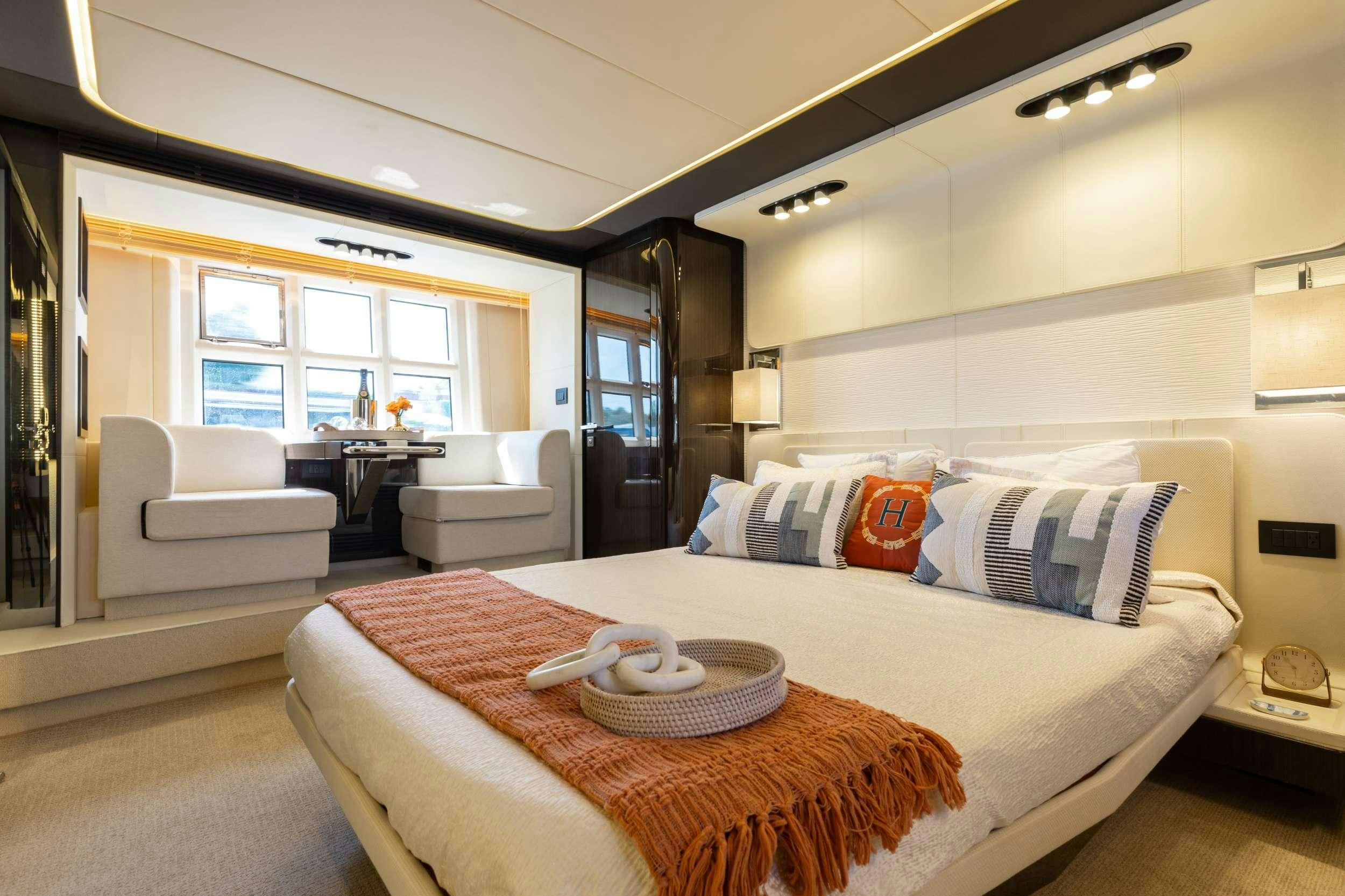 a large bedroom with a bed and a chair aboard HIGH MAINTENANCE Yacht for Charter