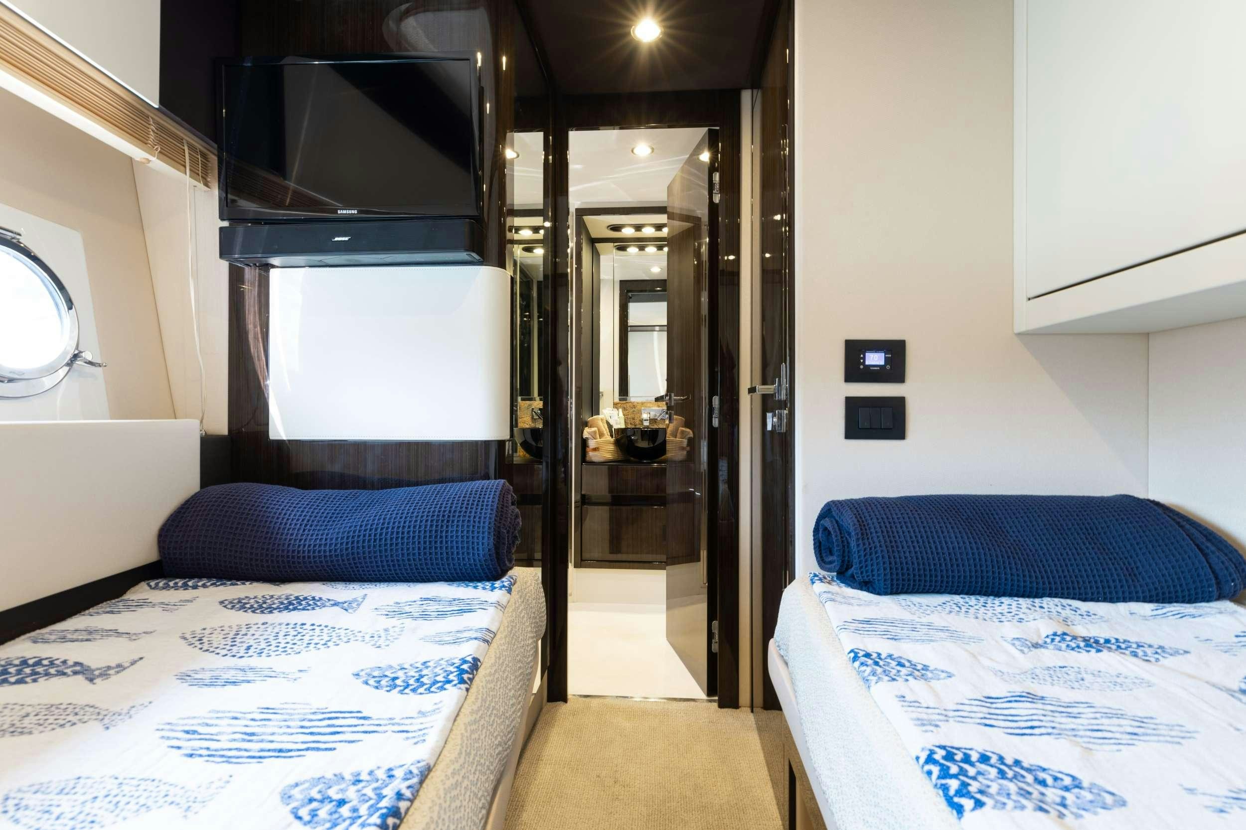 a room with a bed and a television aboard HIGH MAINTENANCE Yacht for Charter