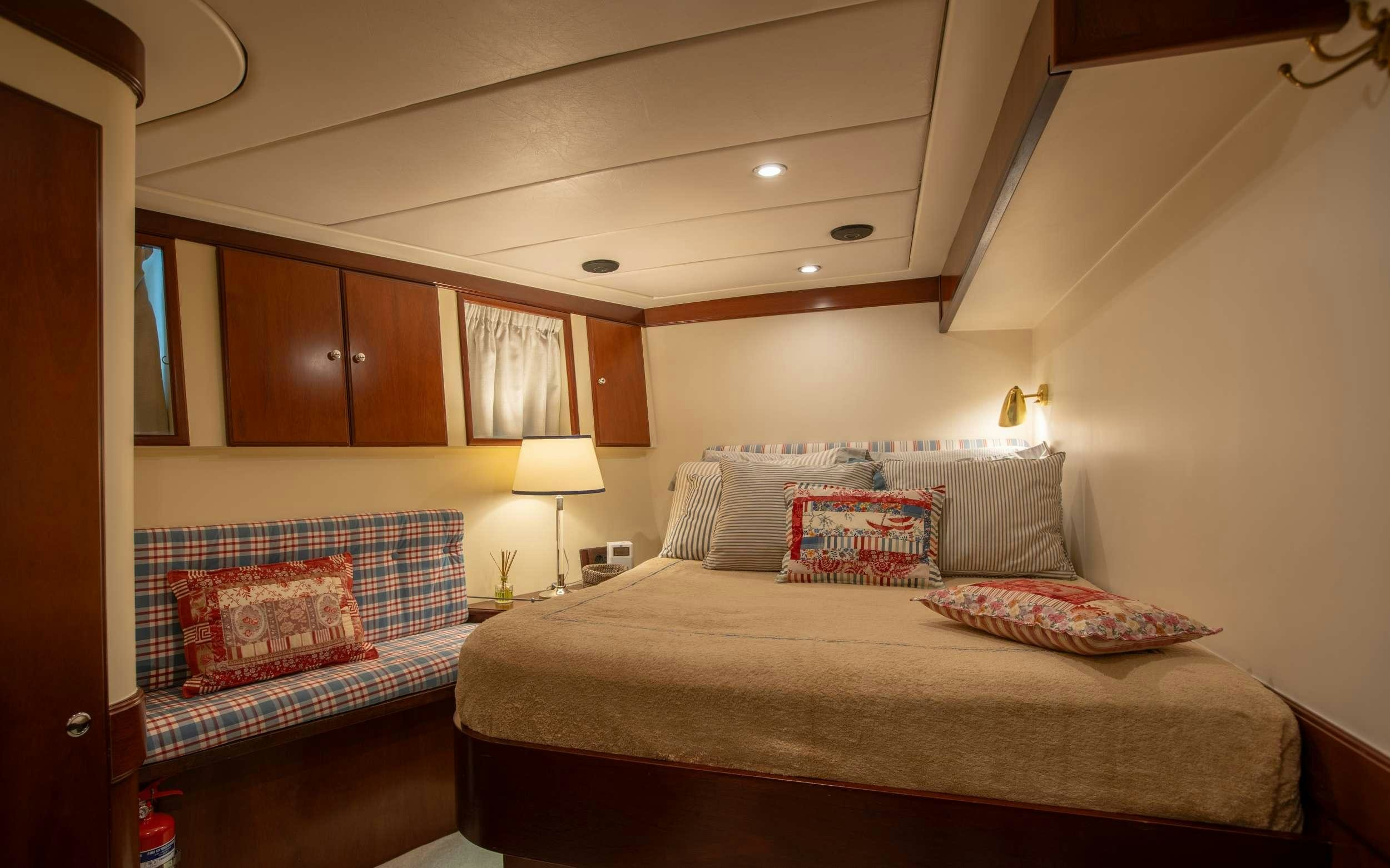a bedroom with a bed and a couch aboard LIBERTY OF LONDON Yacht for Charter