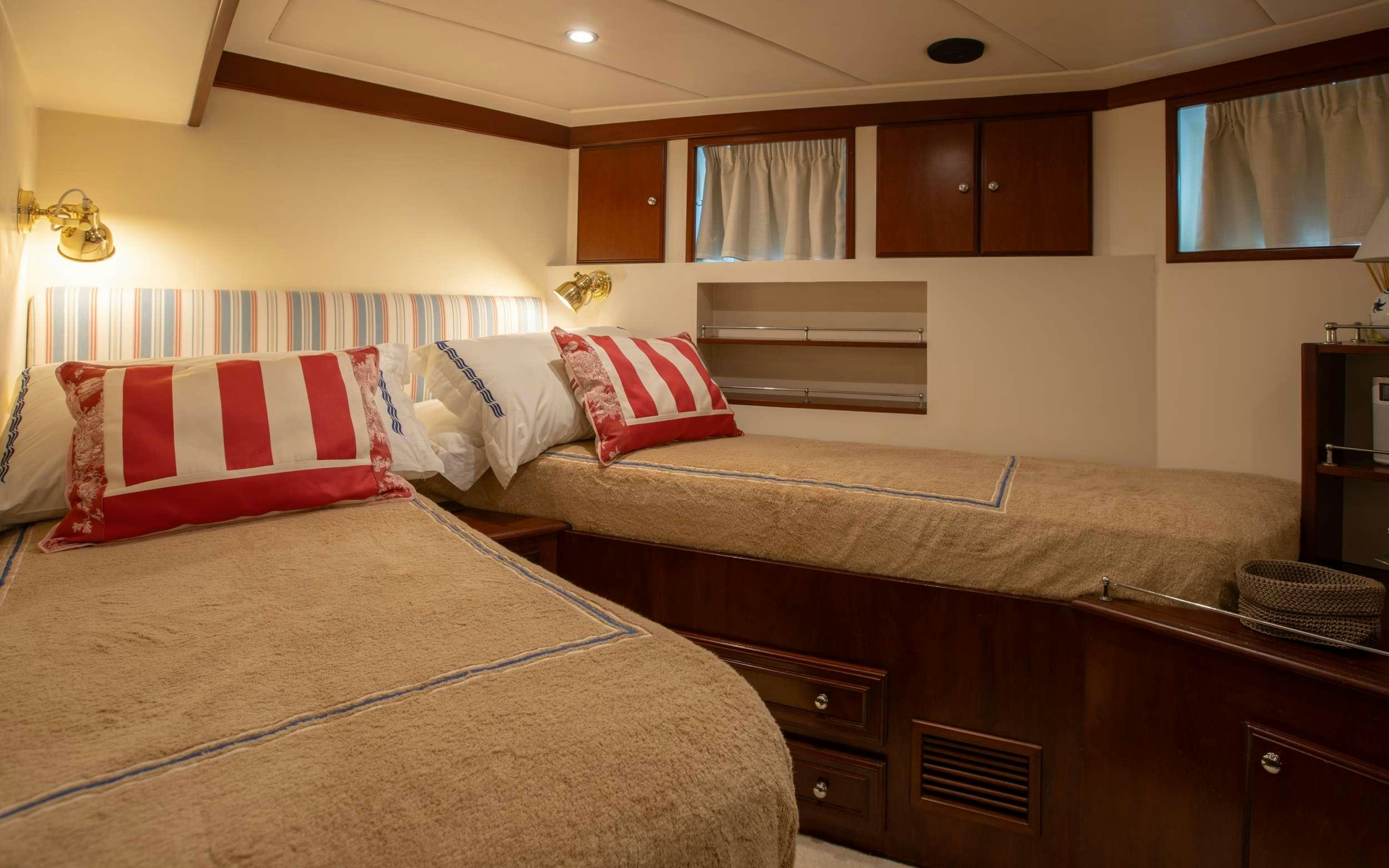 a bedroom with a bed and a desk aboard LIBERTY OF LONDON Yacht for Charter