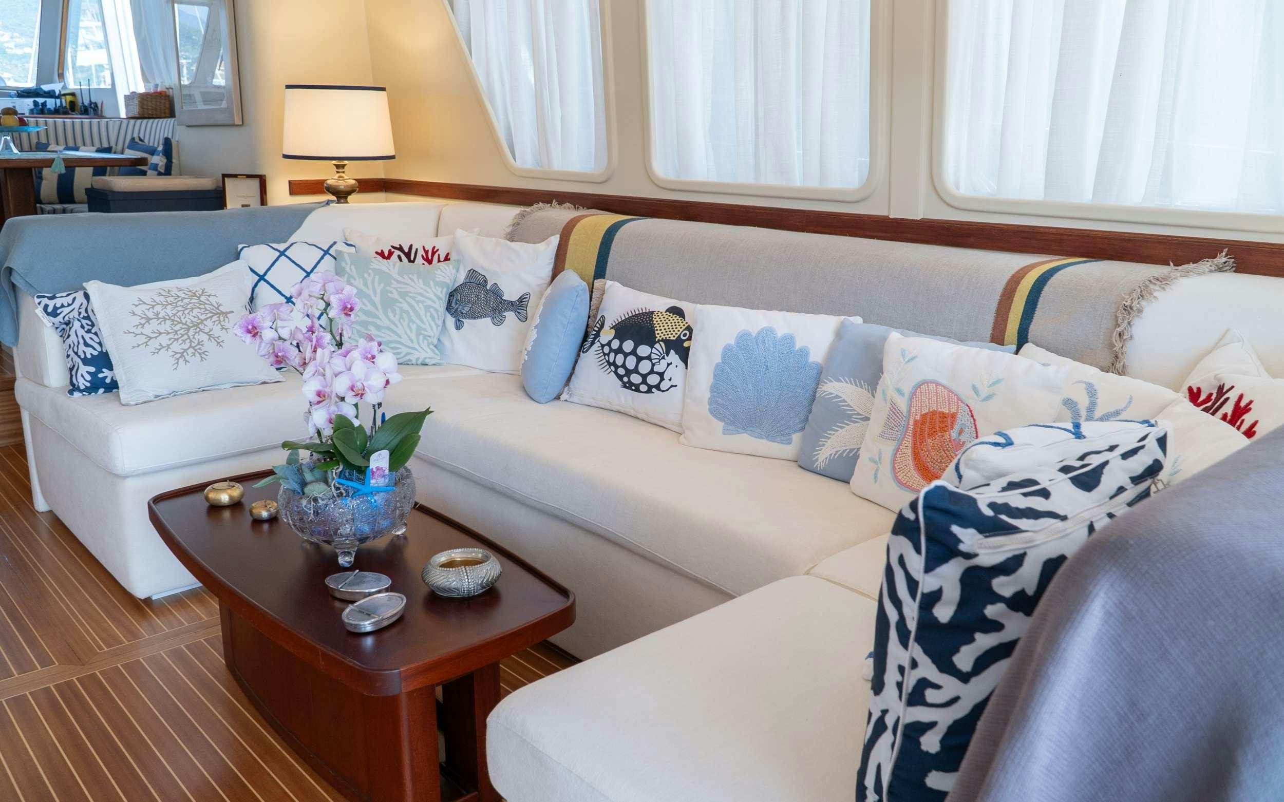 a couch with a coffee table aboard LIBERTY OF LONDON Yacht for Charter