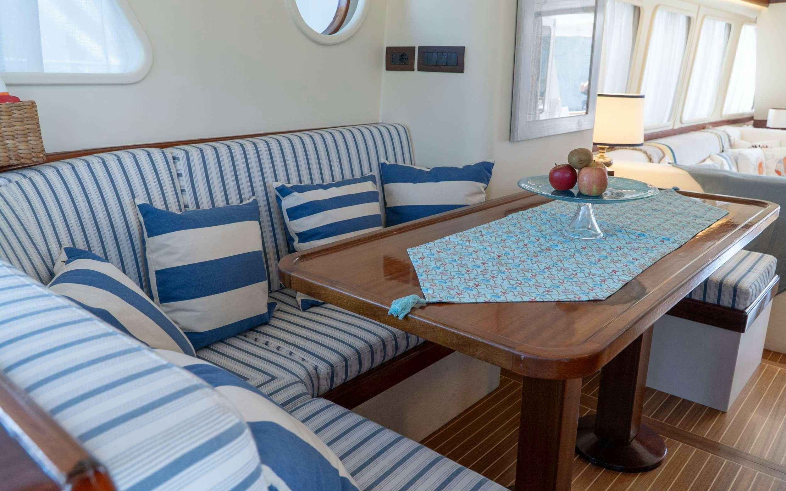 a living room with a couch and a table aboard LIBERTY OF LONDON Yacht for Charter