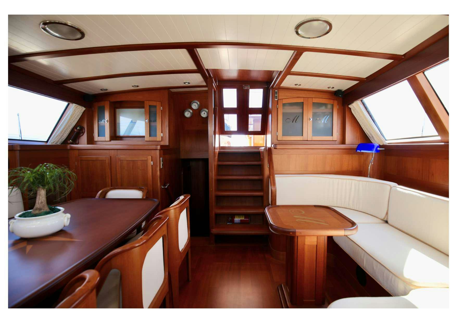 a cabin with a table and chairs aboard MARELLA Yacht for Charter
