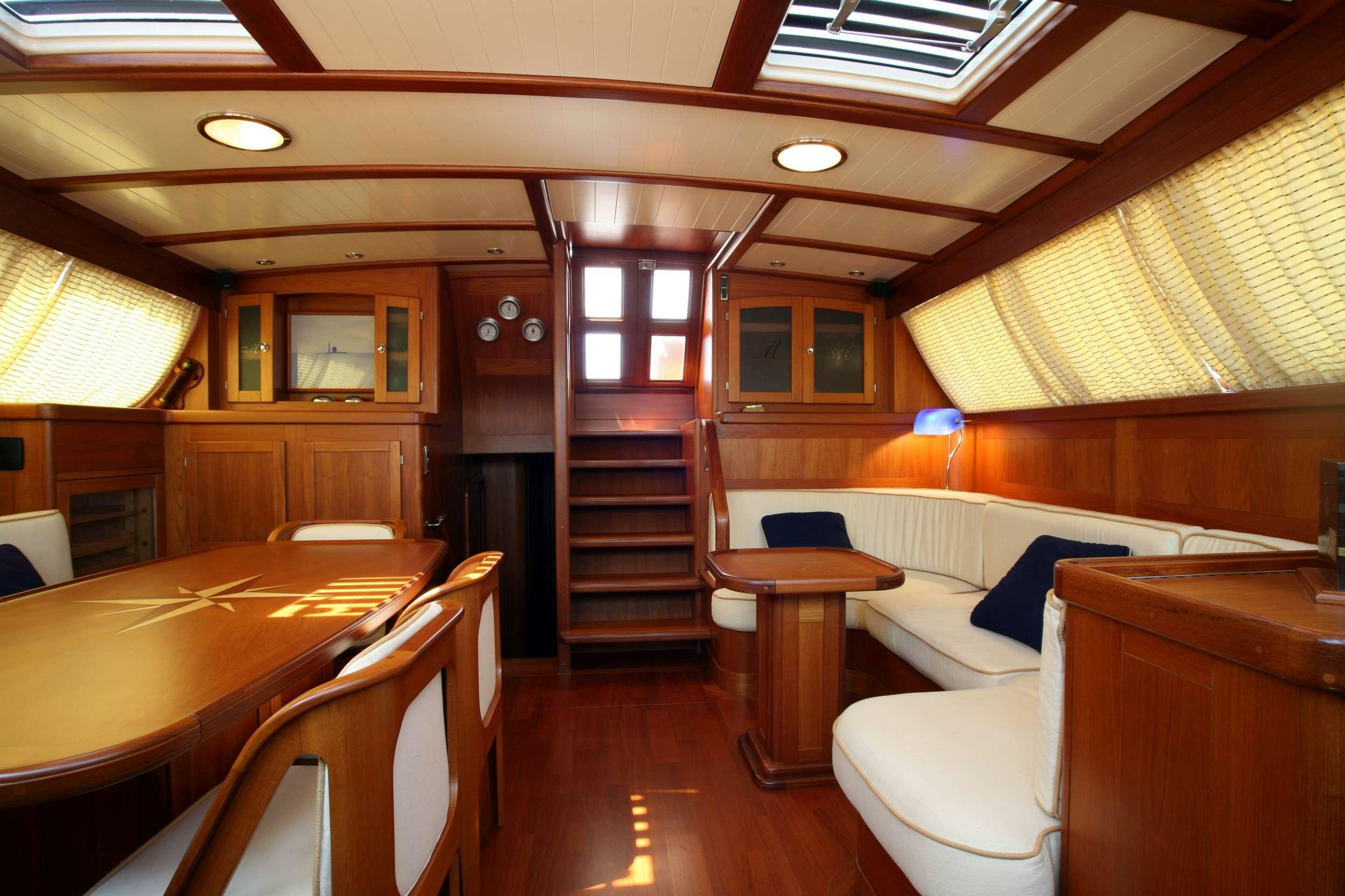 a room with a bed and a table aboard MARELLA Yacht for Charter