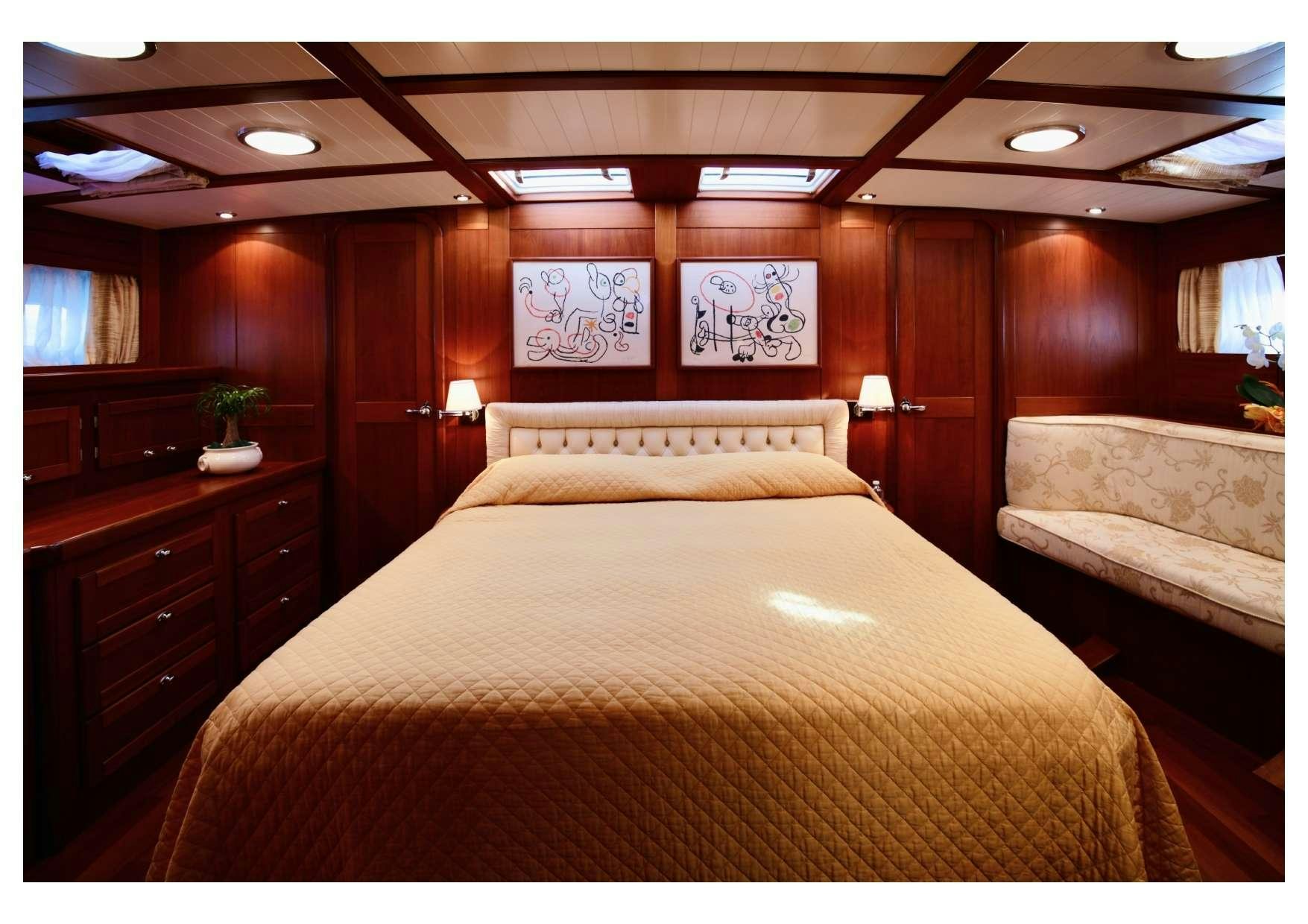 a bed with a wooden headboard aboard MARELLA Yacht for Charter
