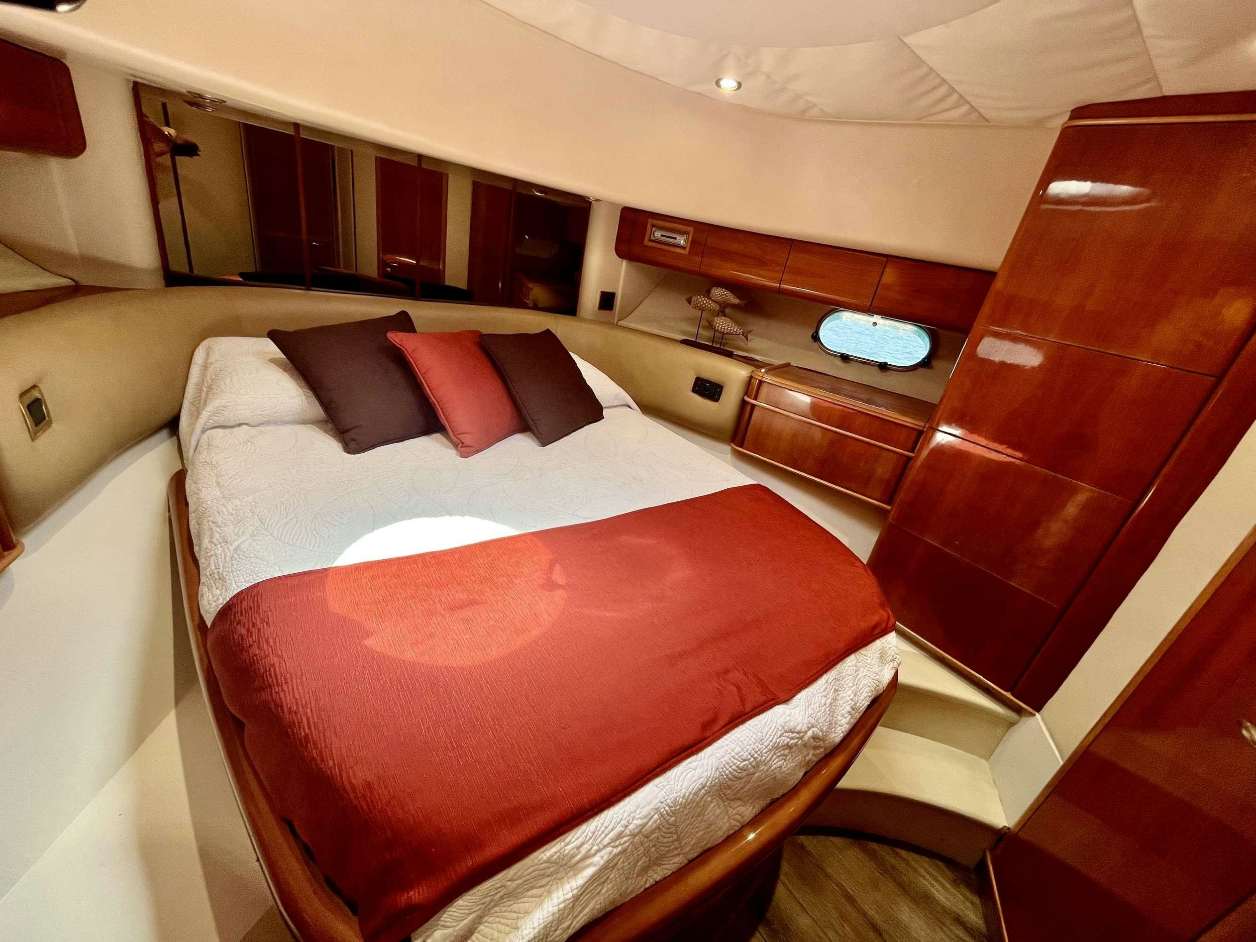 a bed with red pillows aboard MORENA I Yacht for Charter