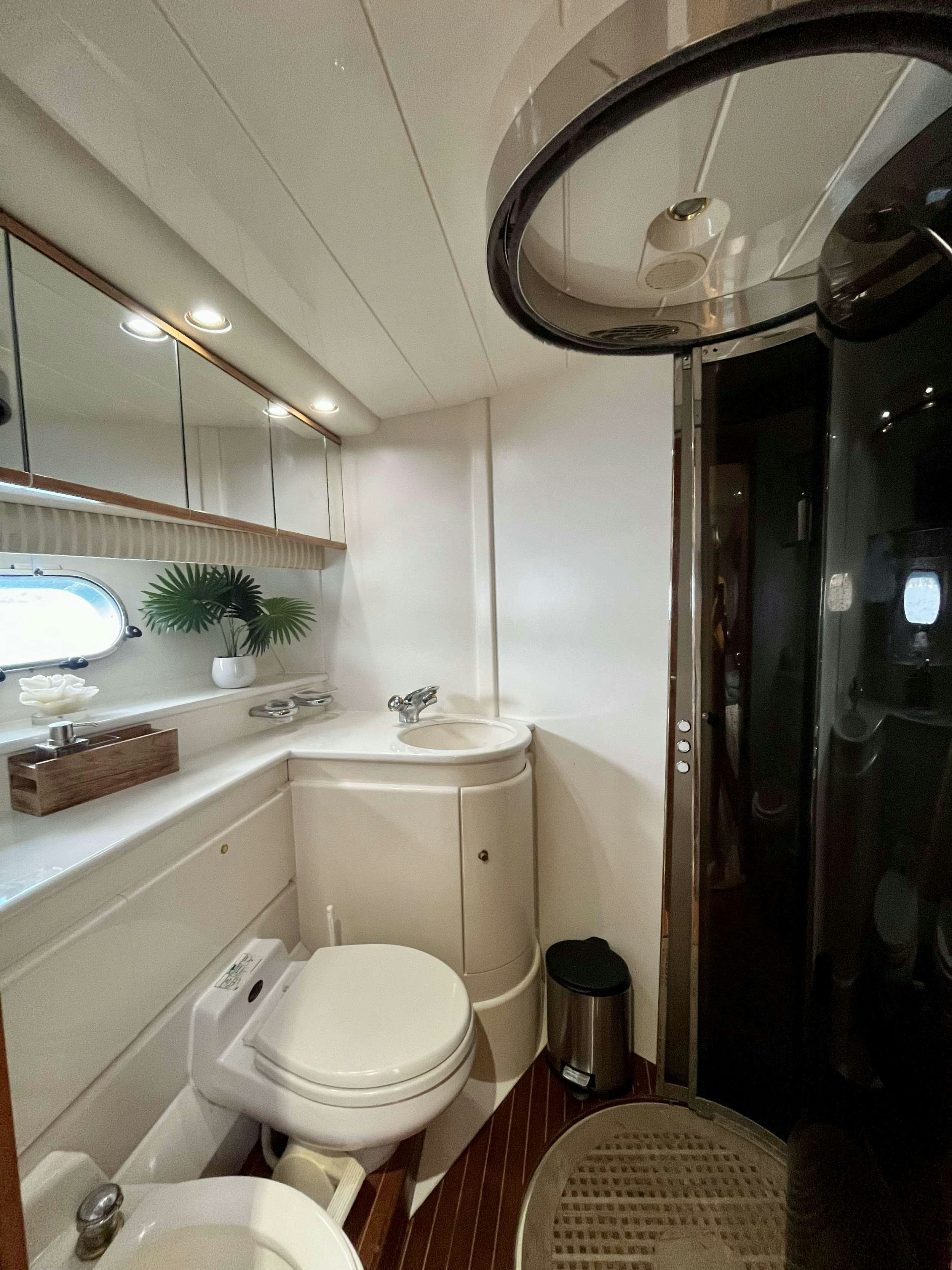 a bathroom with a sink toilet and a mirror aboard MORENA I Yacht for Charter